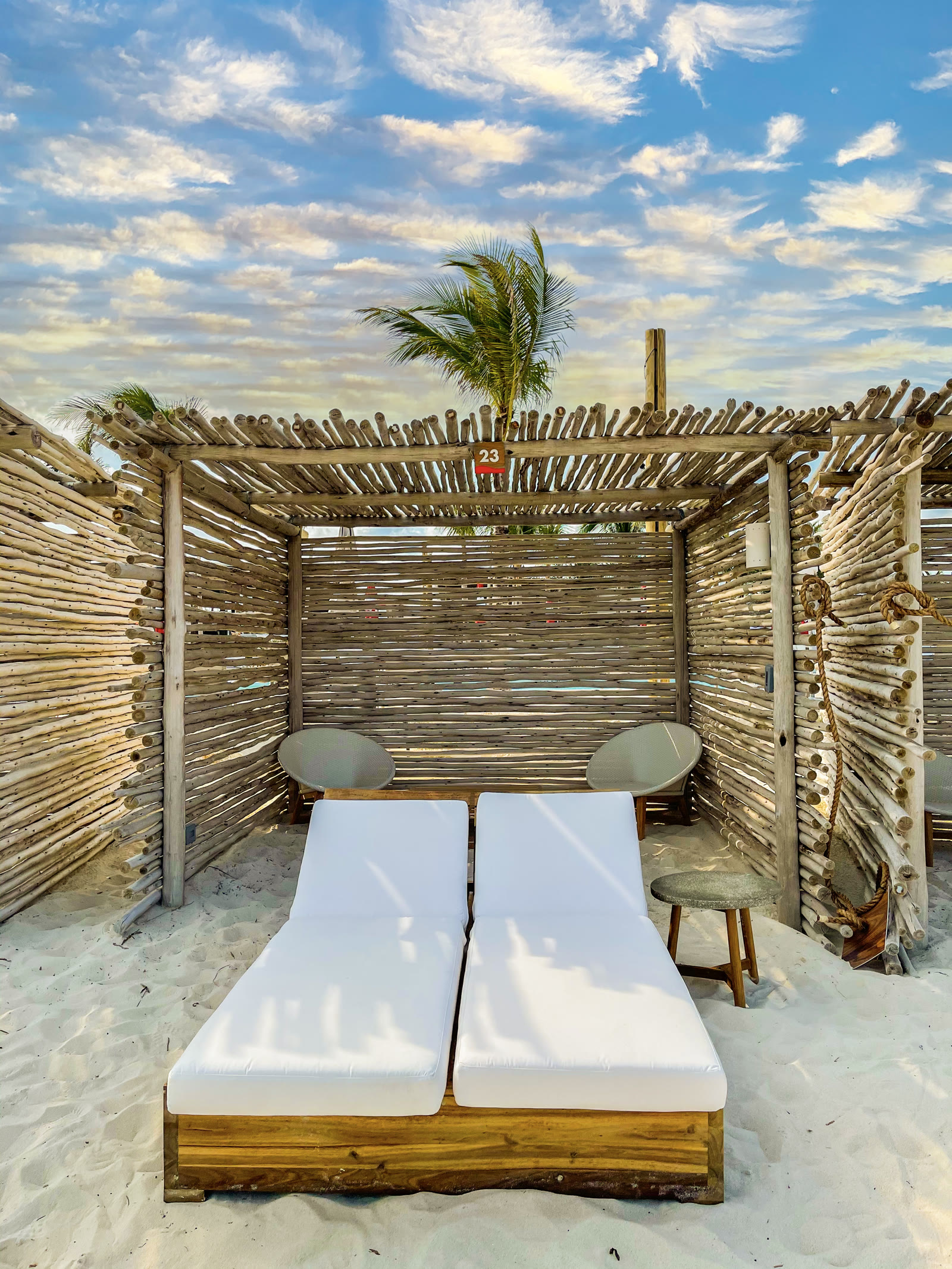 Bimini Beach Club cabana with white loungers on the sand.