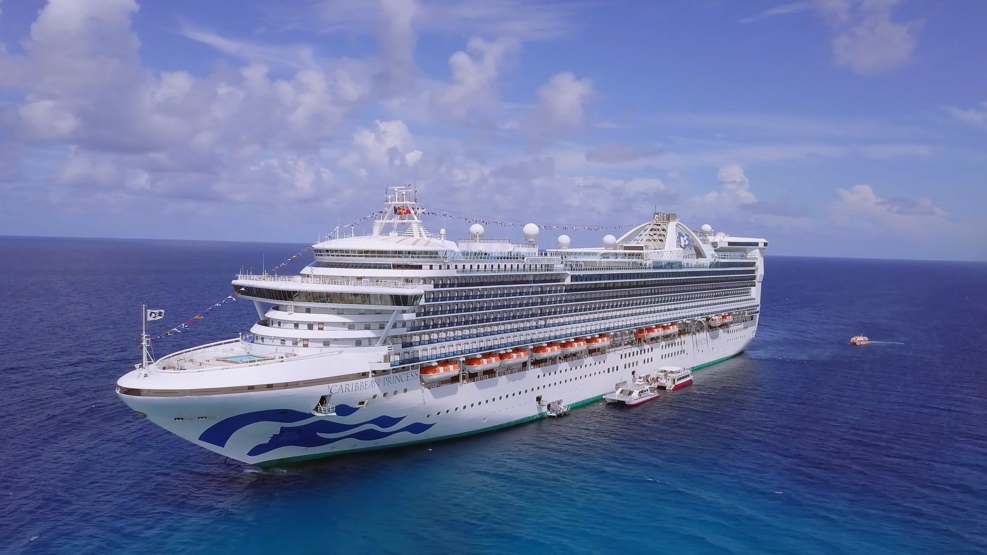 Aerial of Caribbean Princess at sea with tenders alongside in bright blue water