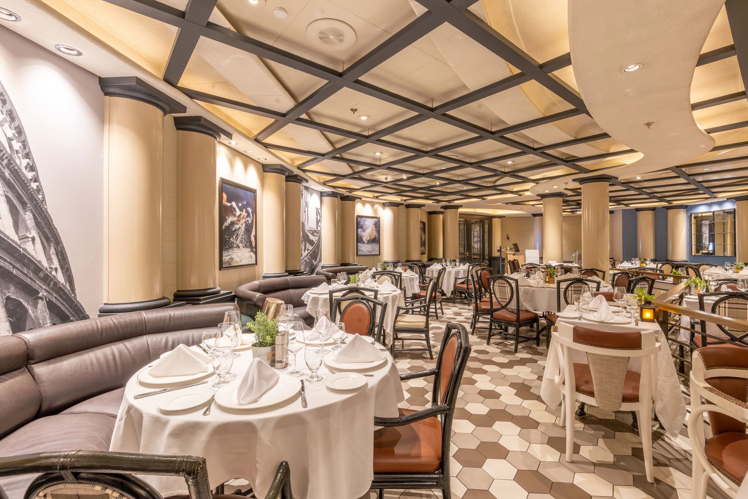 Carnival Adventure Trattoria Italian restaurant with round tables, leather banquettes and hexagon tile floor