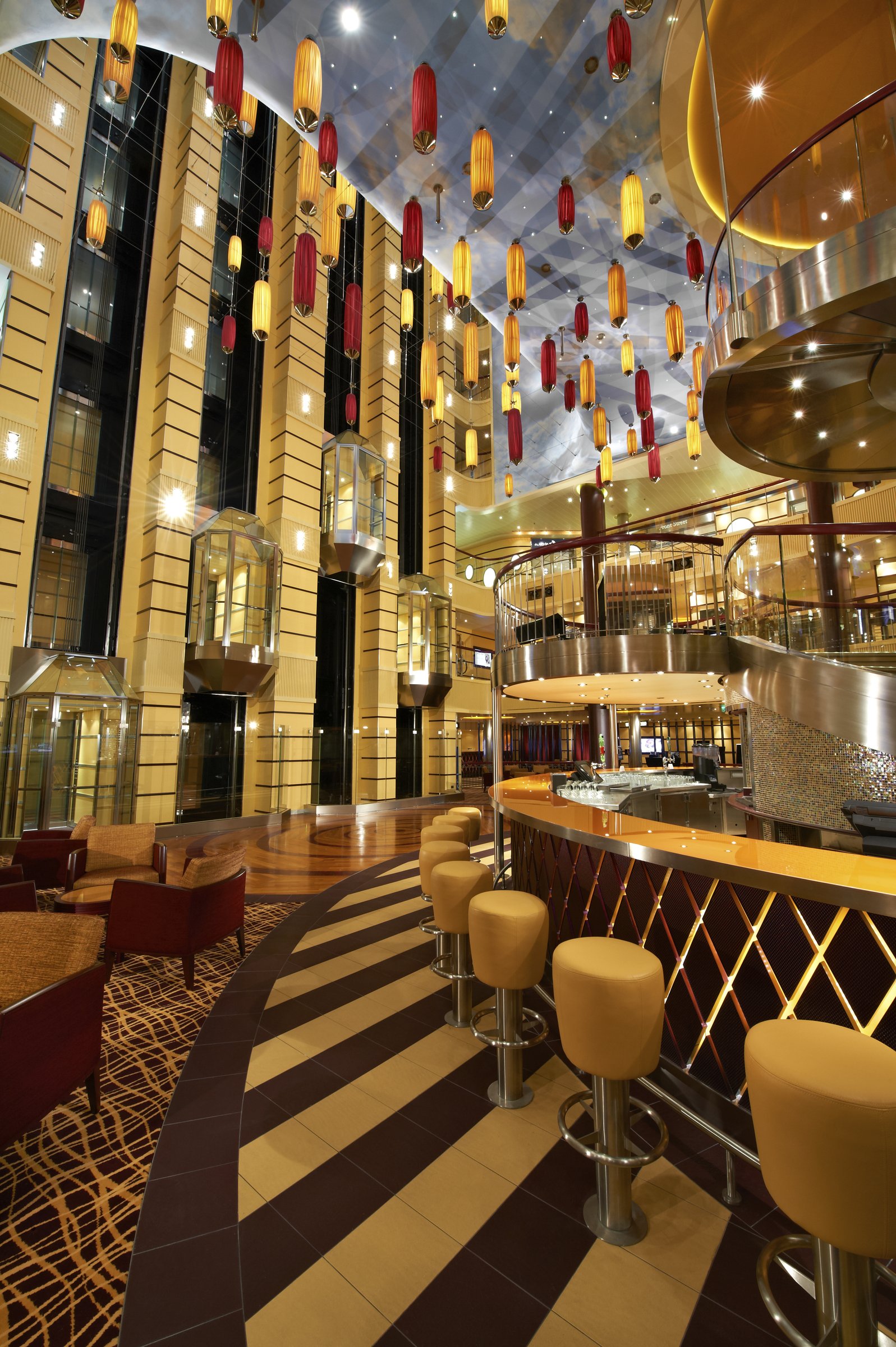 Carnival Breeze multi-deck atrium with hanging lanterns, glass elevators and a gold-striped bar