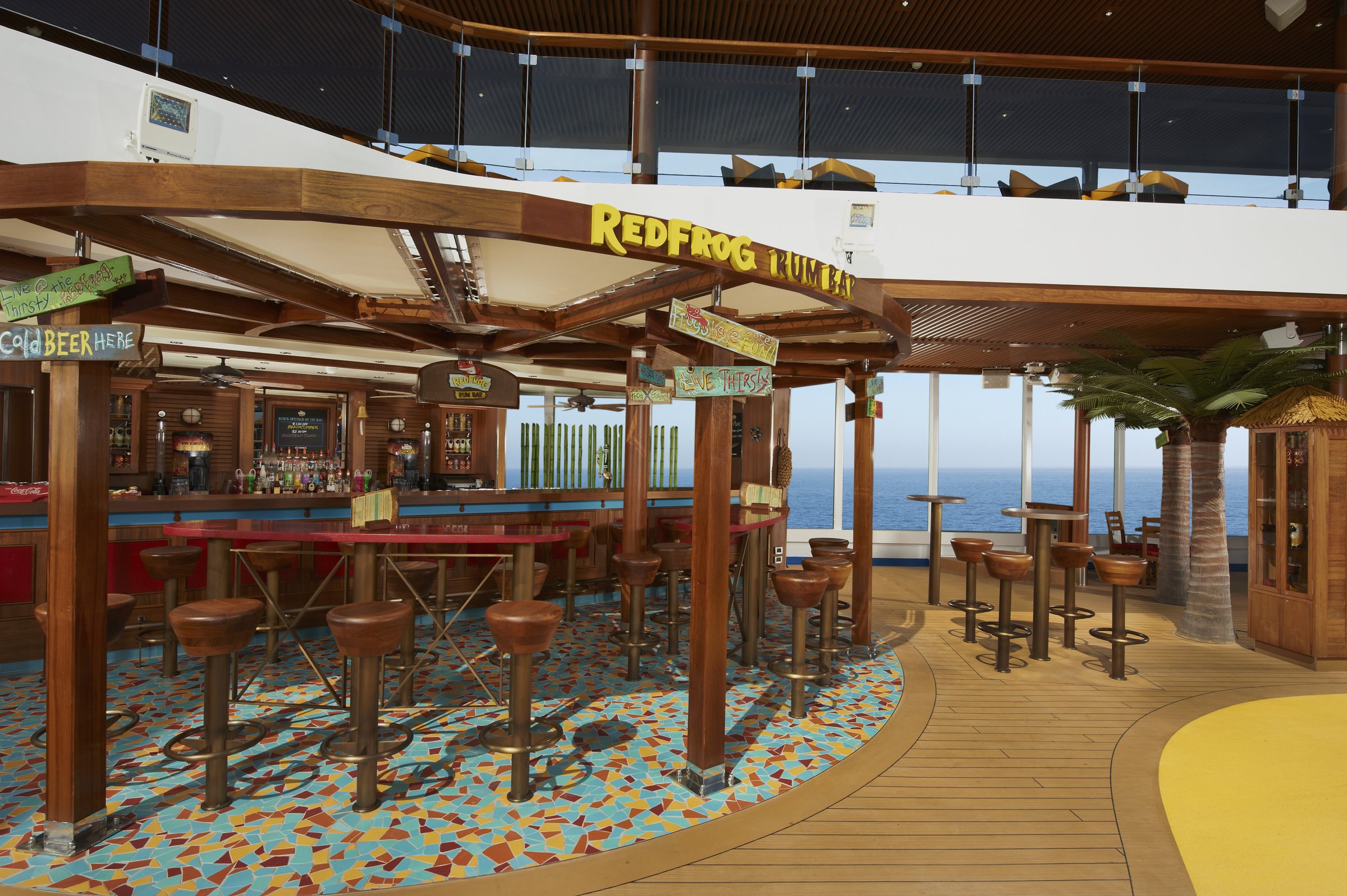 Carnival Breeze RedFrog Pool Bar with a thatched-style canopy, stools and colourful tiled floor