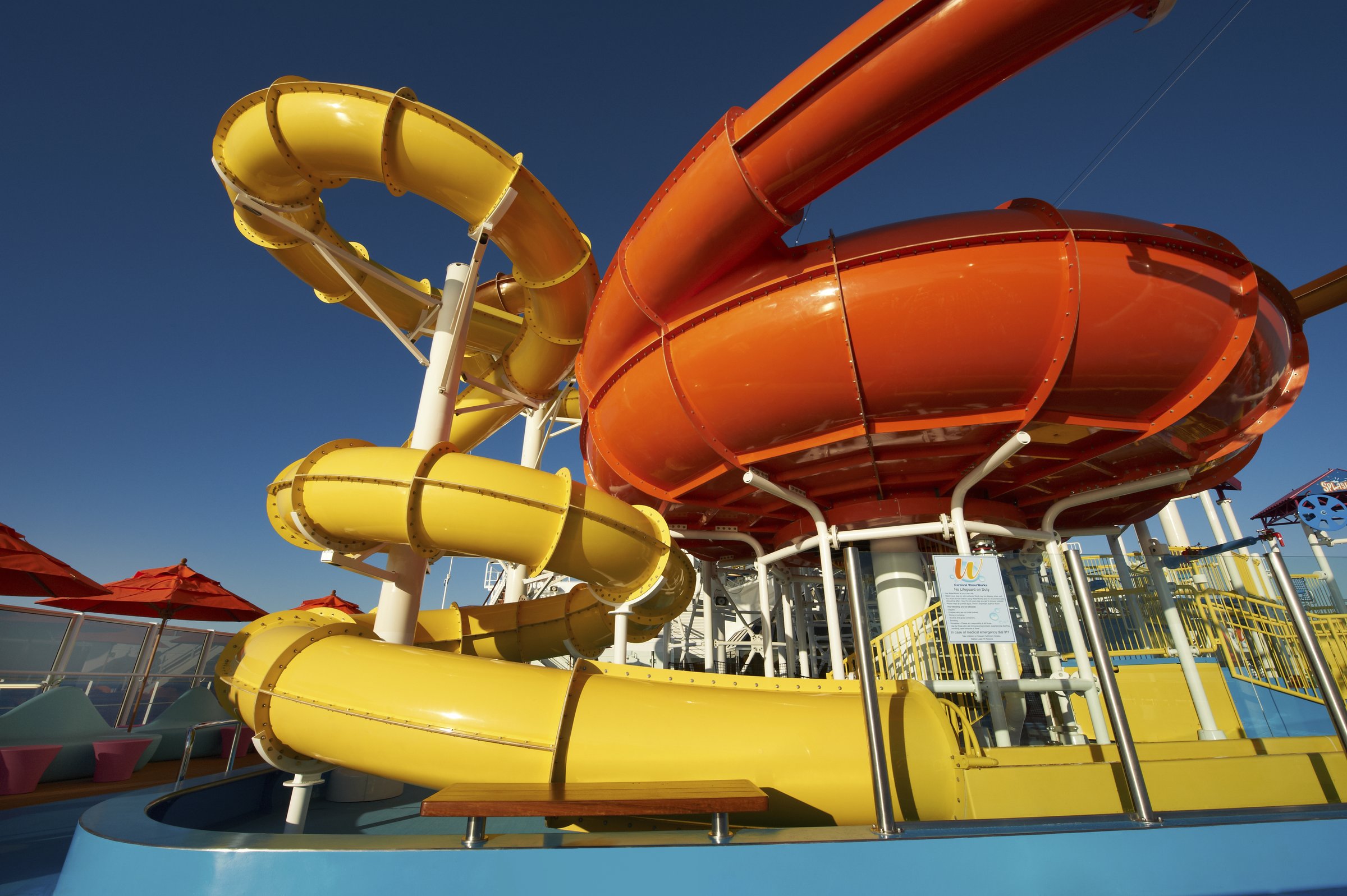 Carnival Breeze WaterWorks yellow and orange slides against a deep blue sky