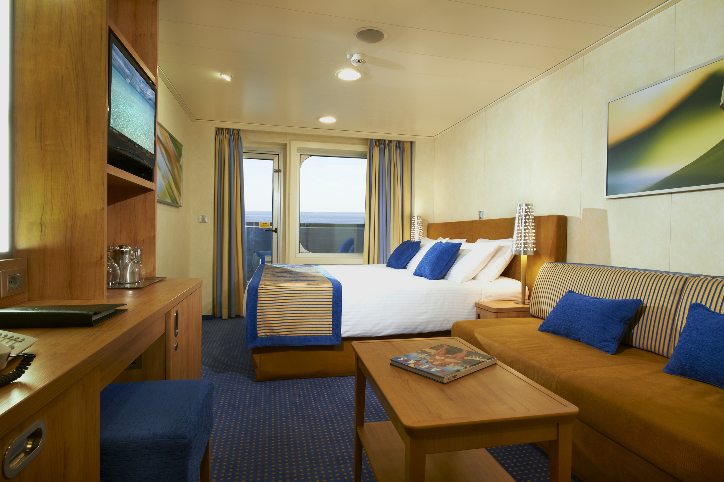 Carnival Breeze balcony stateroom with a double bed, sofa and balcony doors