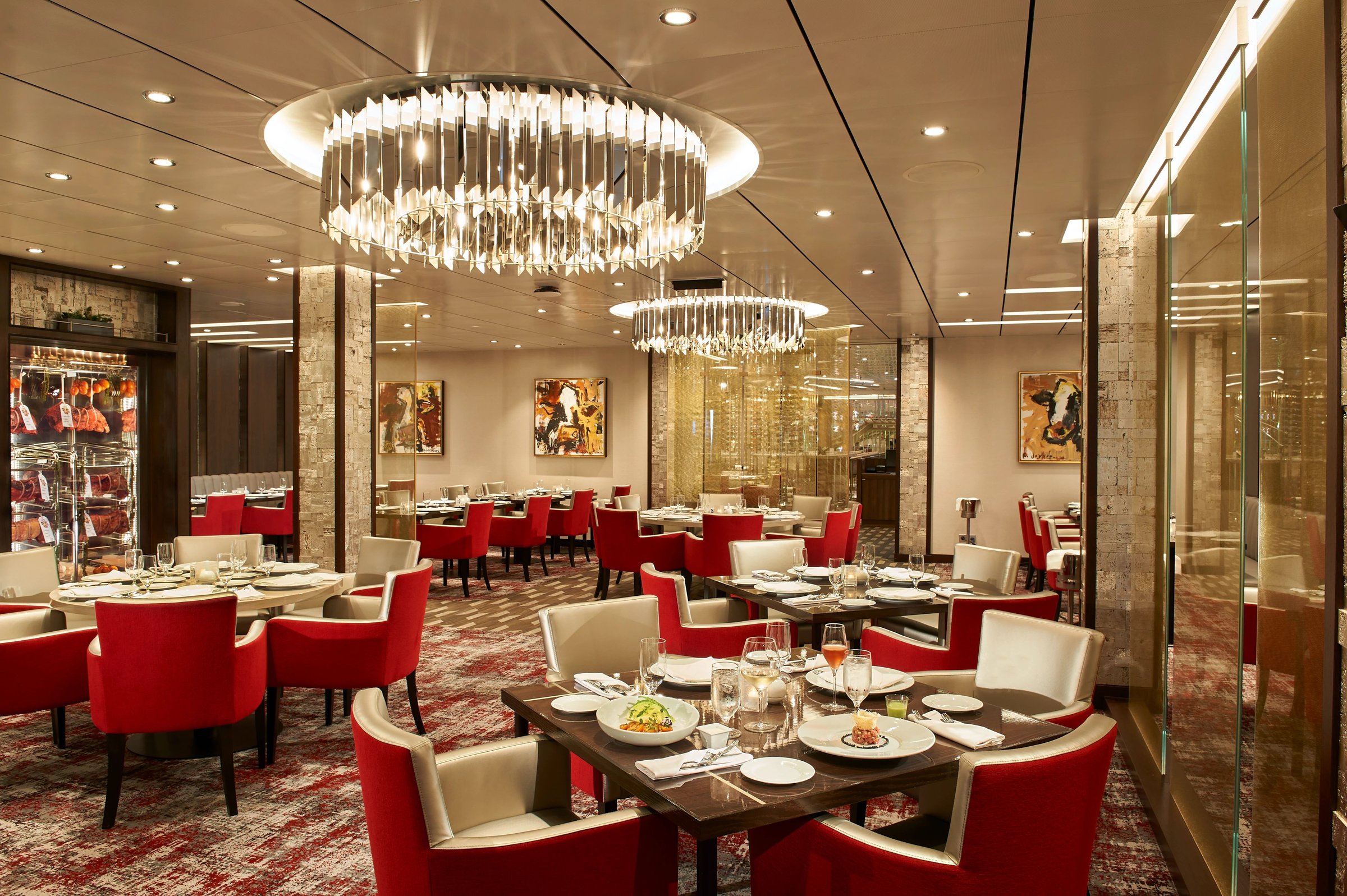 Carnival Celebration Fahrenheit 555 steakhouse with crystal chandeliers and red chairs