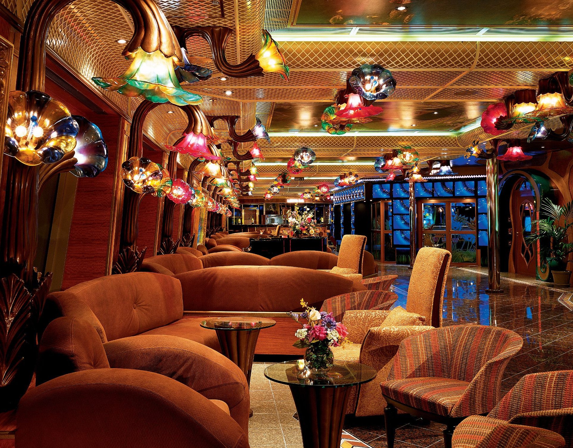 Carnival Conquest lounge with orange sofas and colorful glass pendant lights