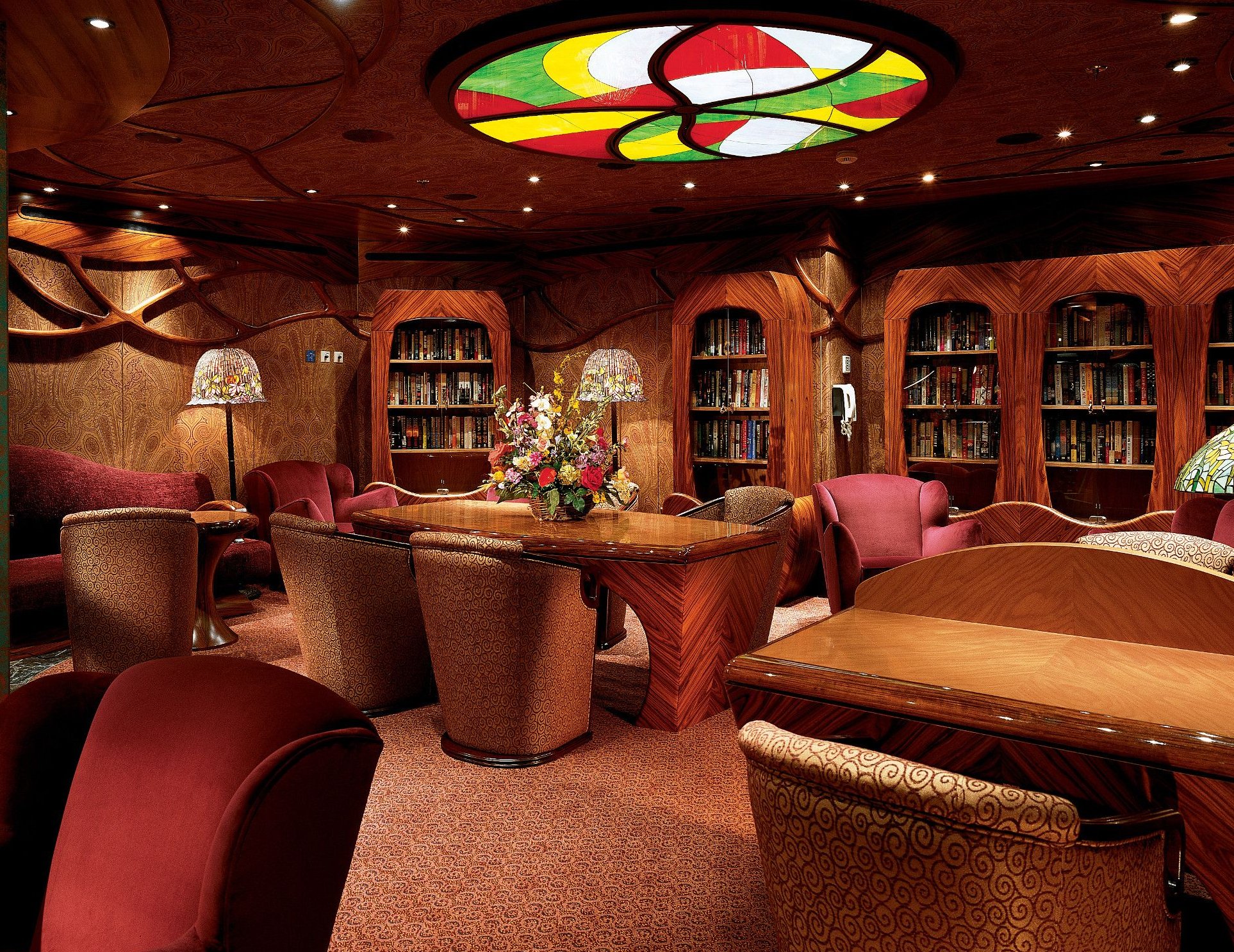 Carnival Conquest card room and library lounge with wood bookcases and stained glass ceiling