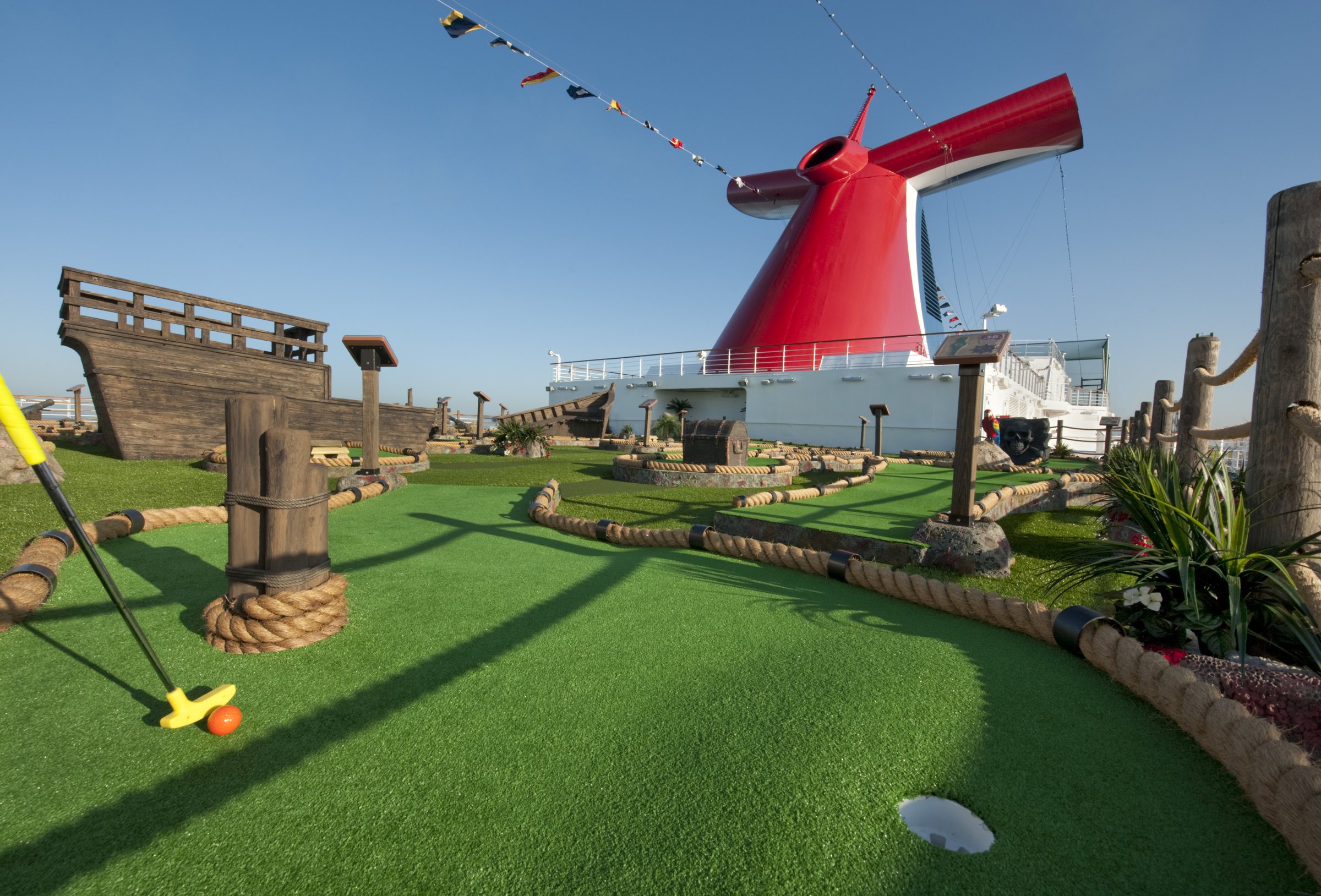 Carnival Dream pirate-themed mini golf course beneath the red funnel on a sunny day