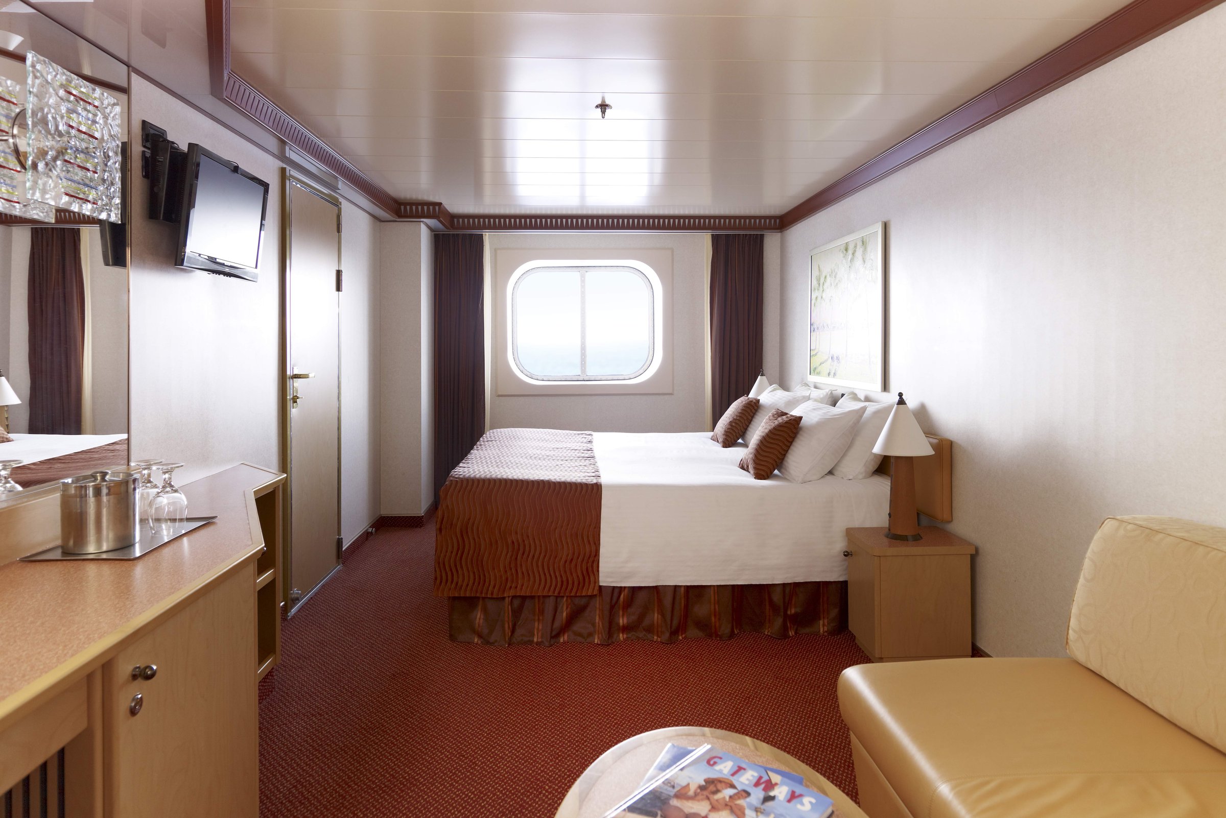 Carnival Dream oceanview stateroom with a double bed, porthole window and sofa
