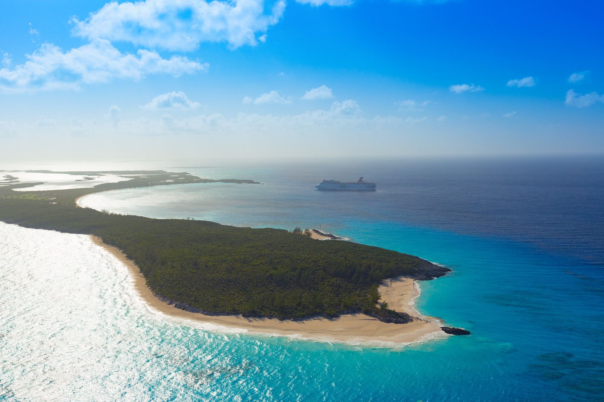 Carnival Elation at anchor off Half Moon Cay, sunny aerial of the island and sandy point