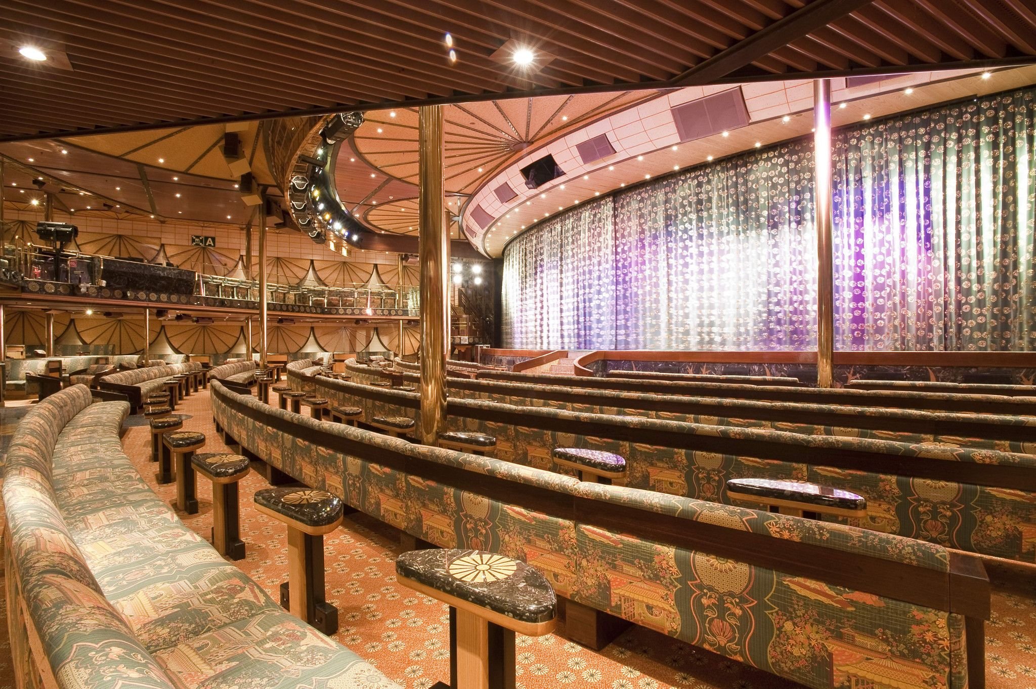 Carnival Elation Mikado lounge, tiered patterned banquettes facing a curtained stage