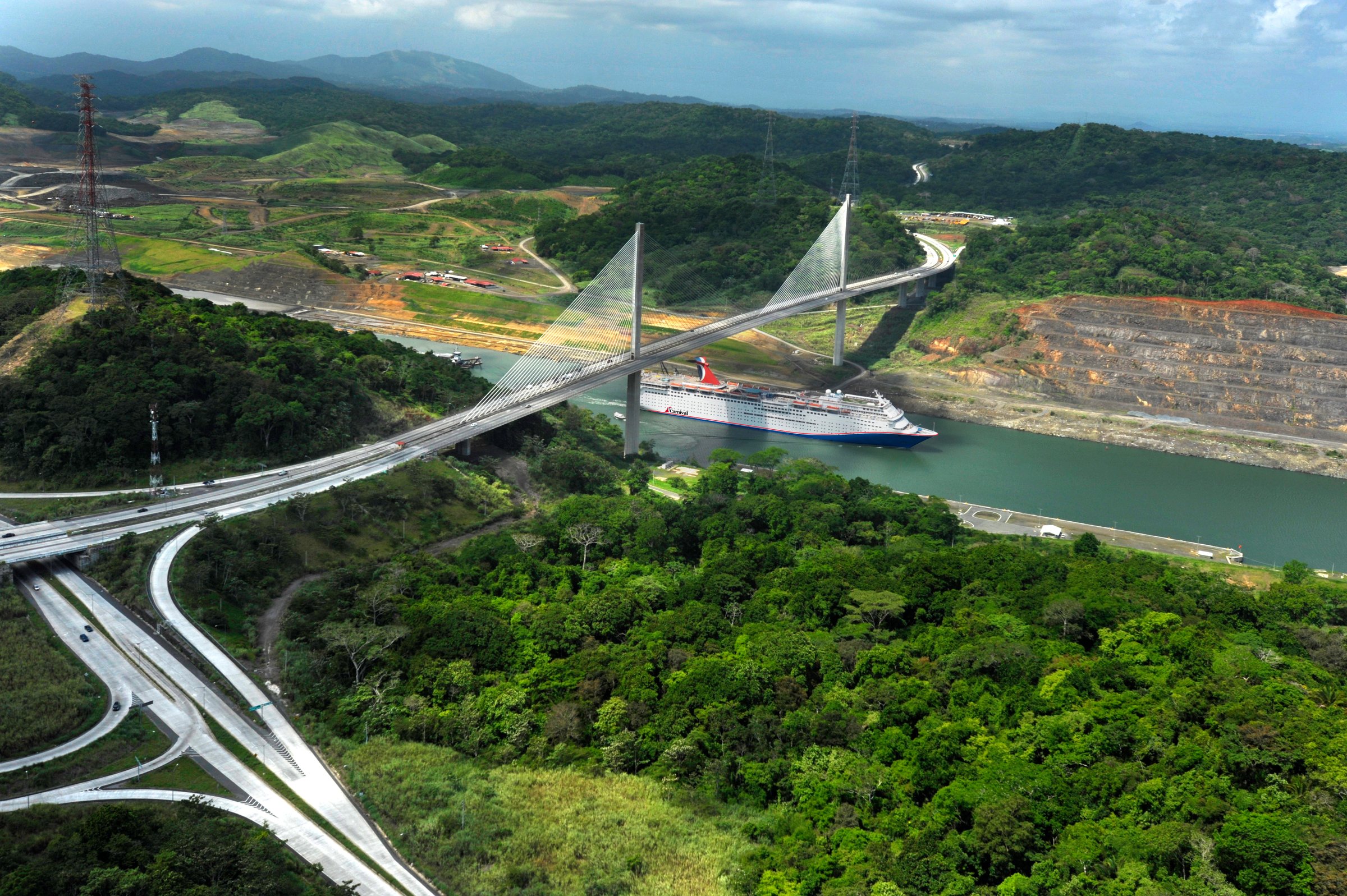 Carnival Elation sailing the Panama Canal beneath the Centennial Bridge, sunny daylight aerial
