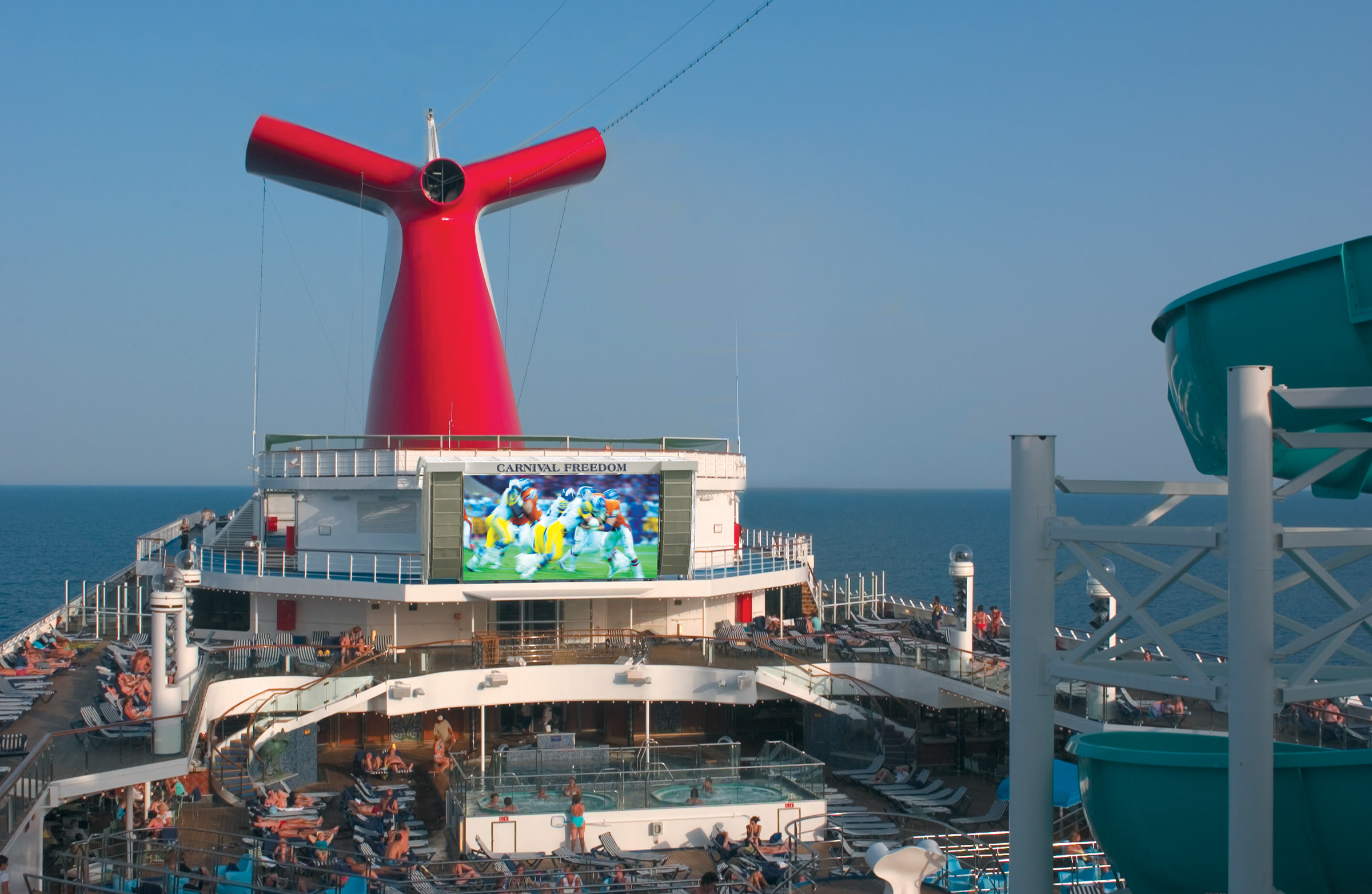 Carnival Freedom Lido deck with funnel and outdoor screen, sunny midday