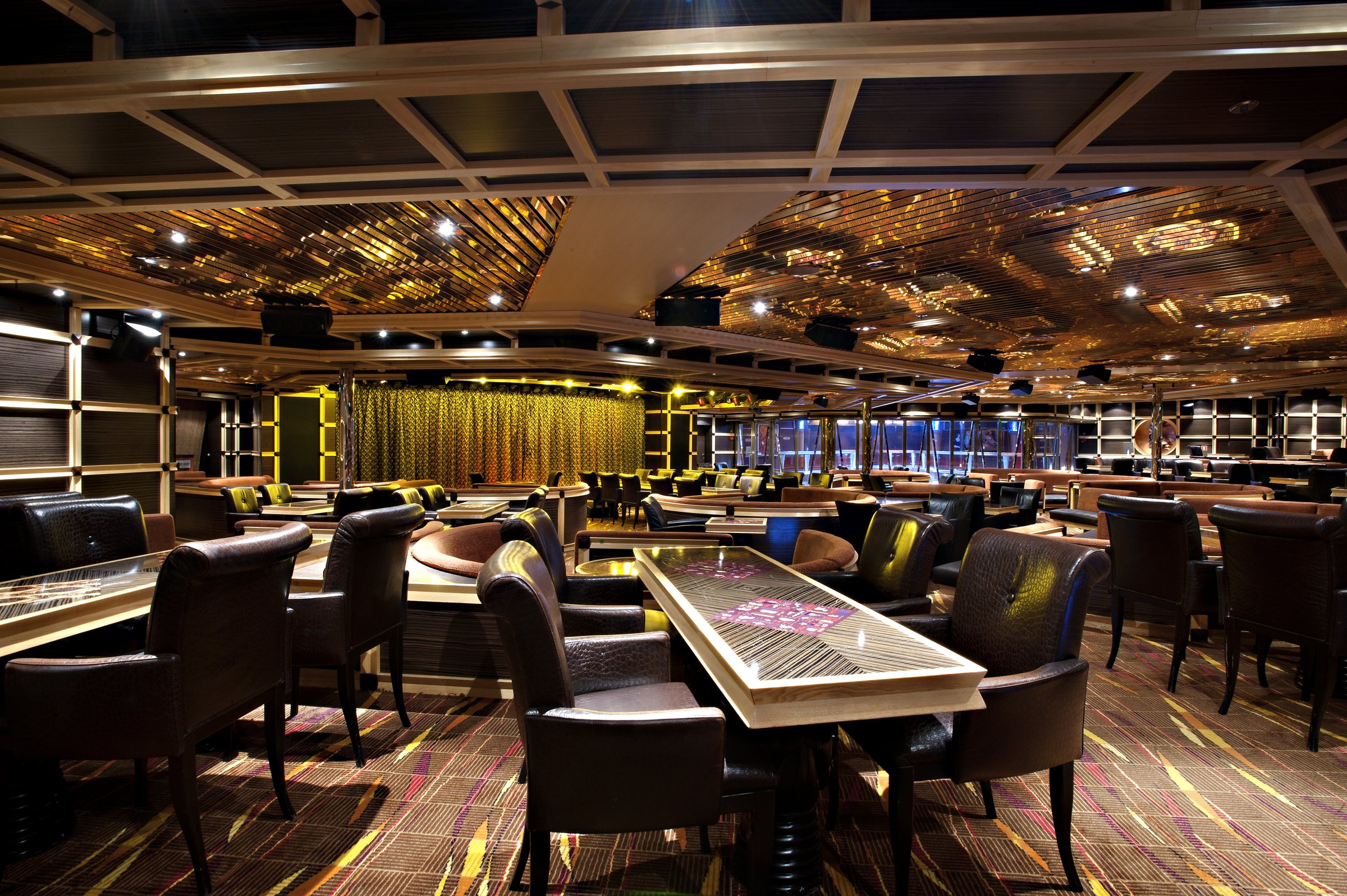 Carnival Glory Ebony Lounge with leather armchairs and a patterned wood ceiling