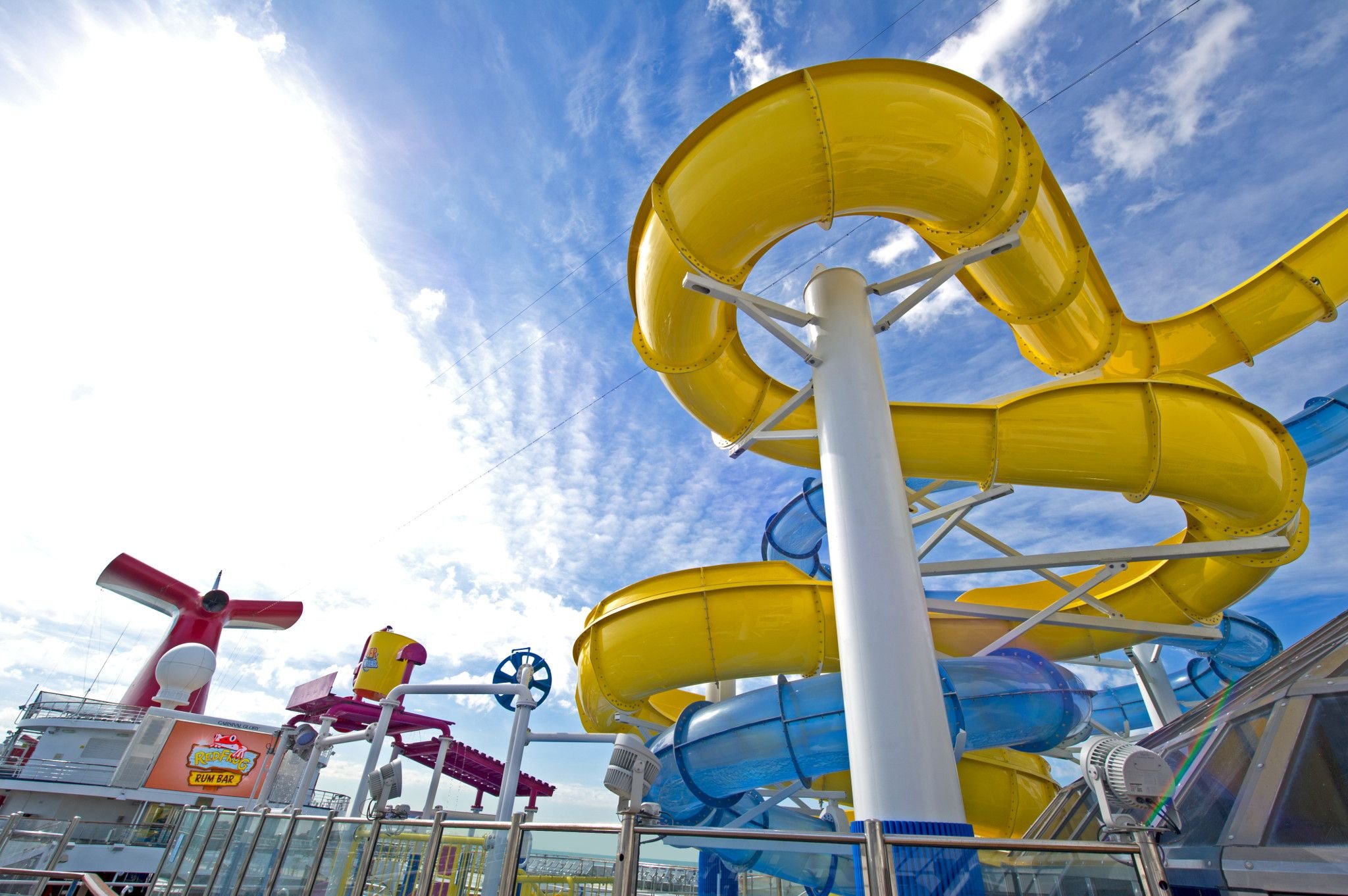 Carnival Glory WaterWorks yellow and blue slides with the red funnel under a bright blue sky