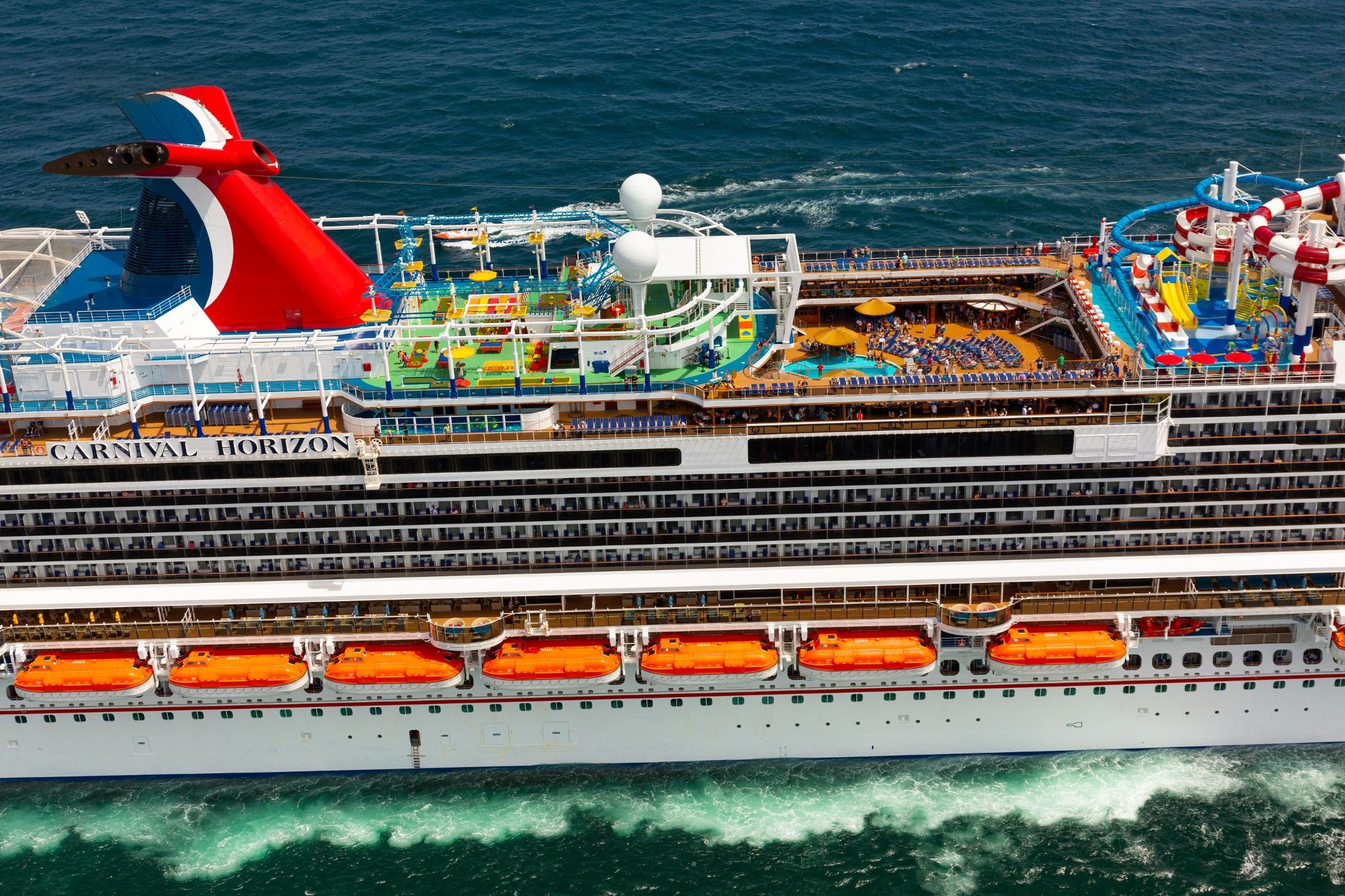 Aerial broadside of Carnival Horizon showing its name on the hull, the funnel, SportSquare and WaterWorks