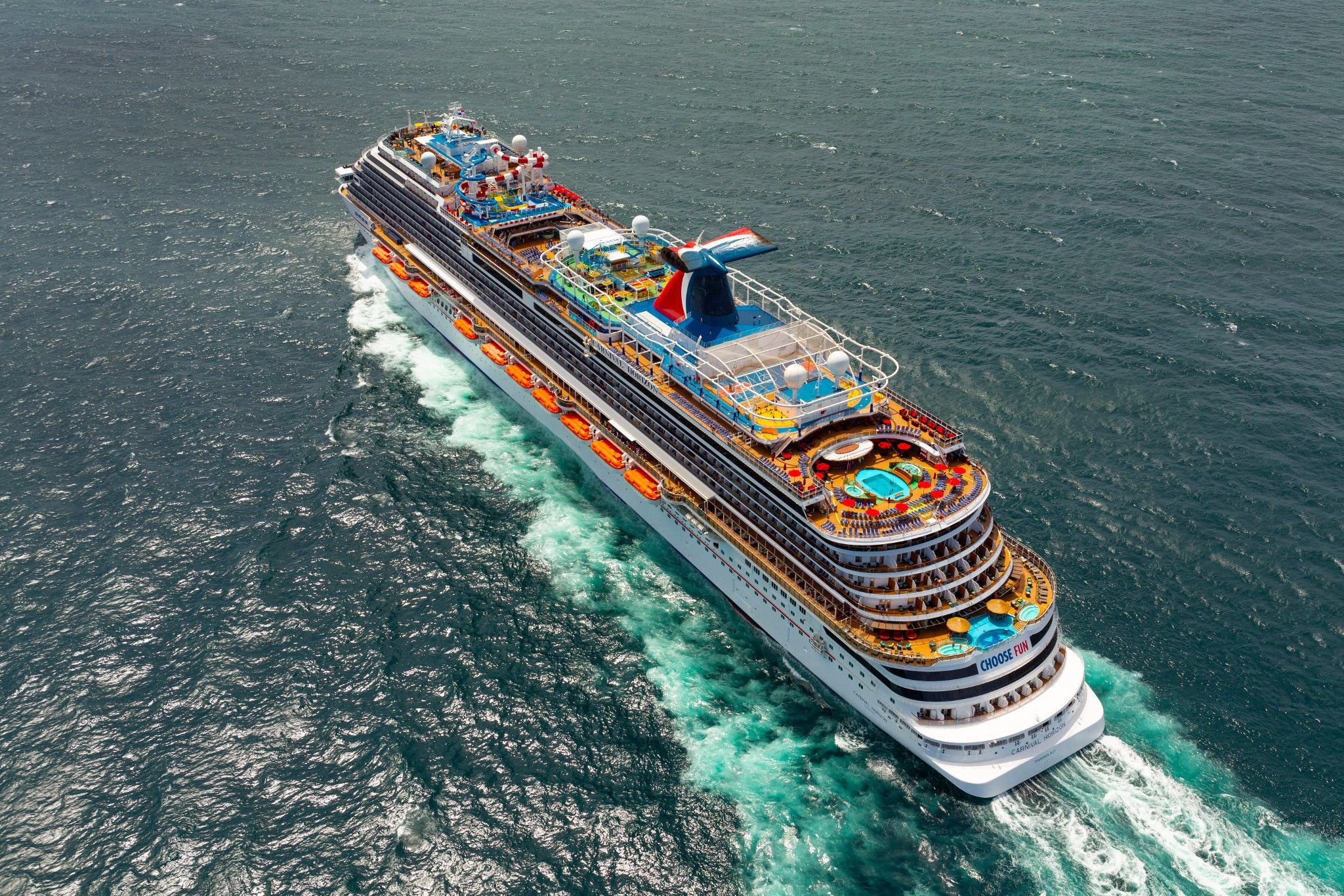 Aerial of Carnival Horizon under way off San Juan, its open decks and red-and-blue funnel in full view