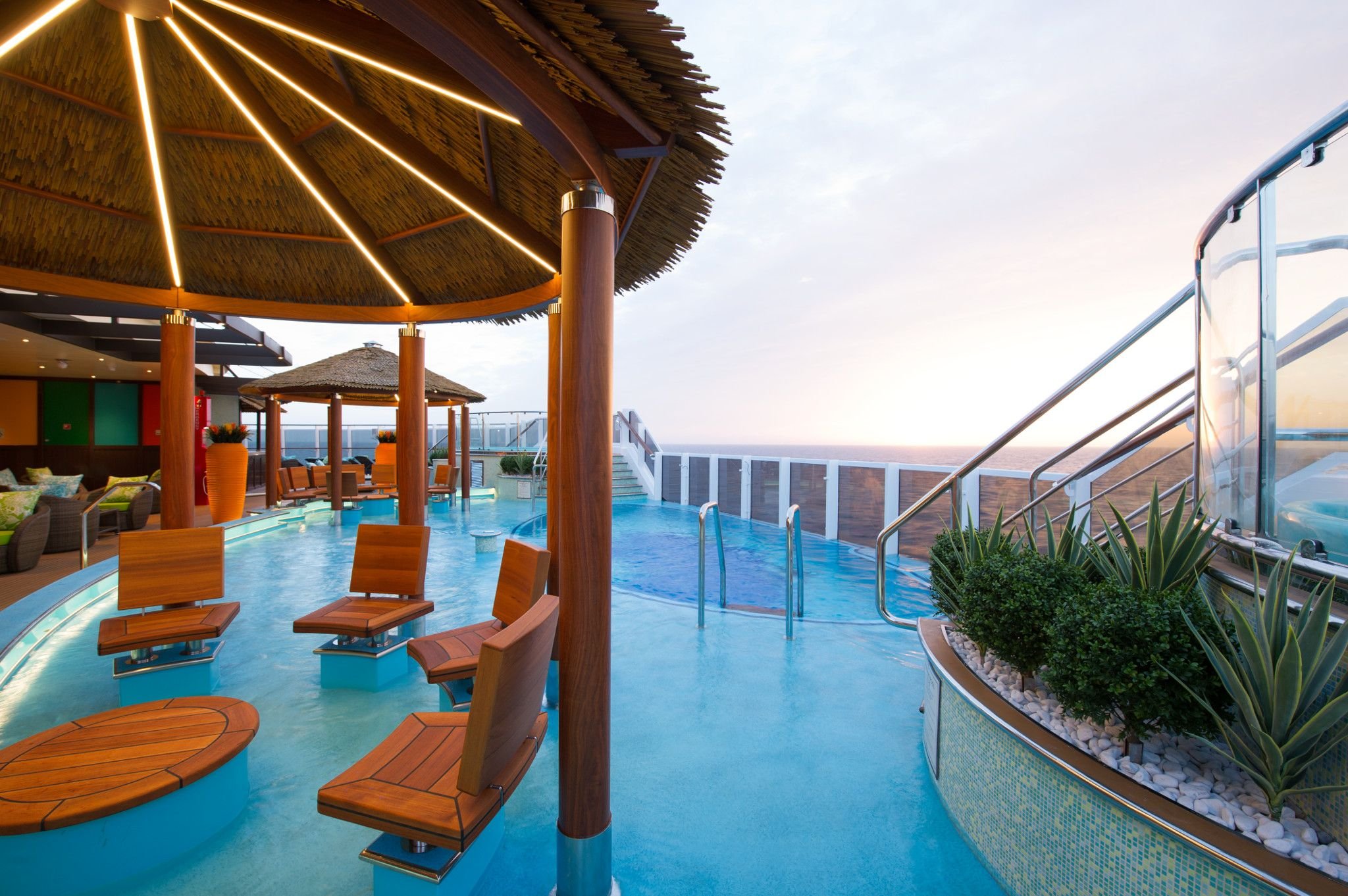Carnival Horizon Havana pool with swim-up bar seats beneath a thatched palapa, sea view beyond