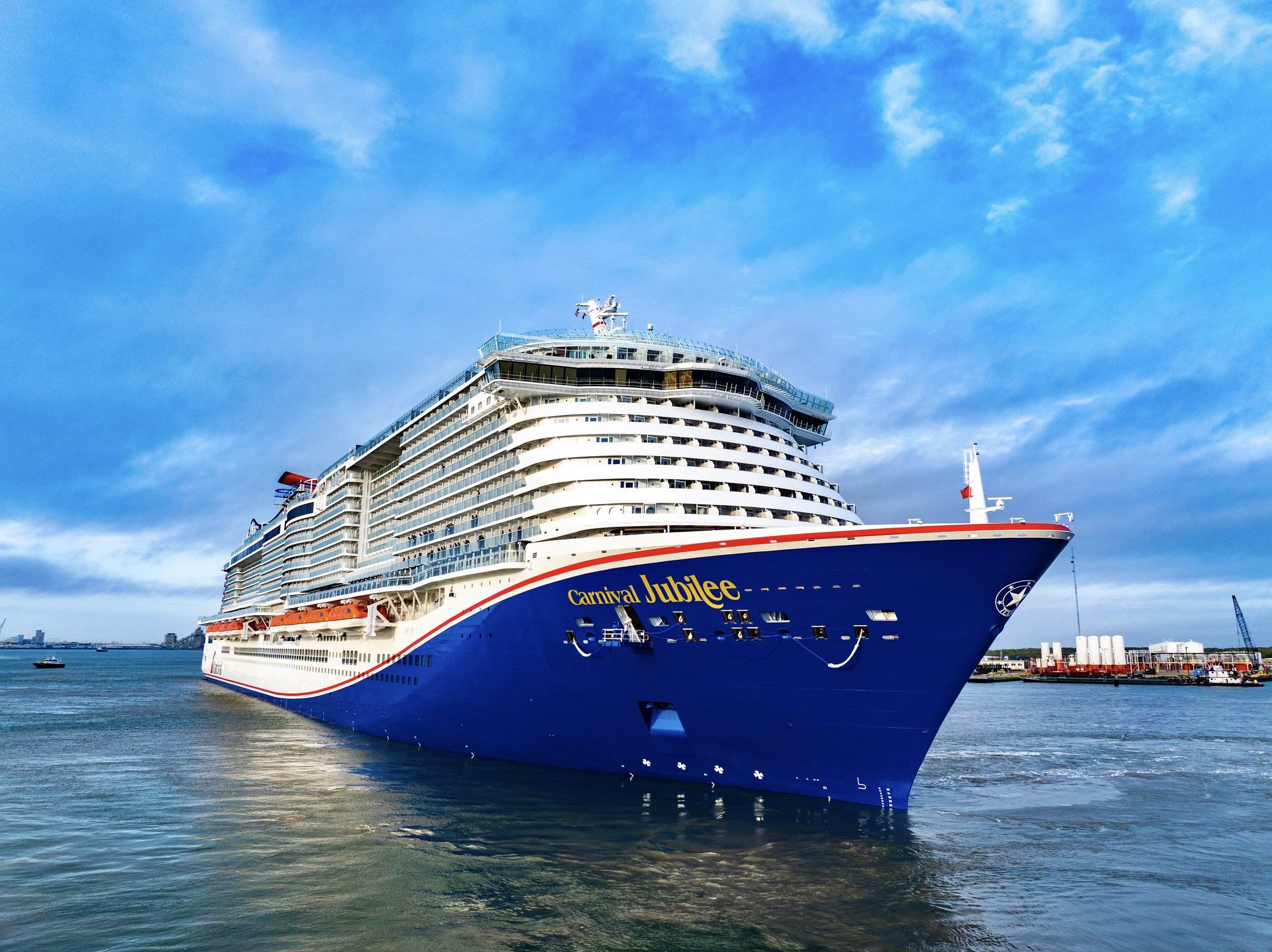 Carnival Jubilee bow and blue hull in port under a bright blue sky