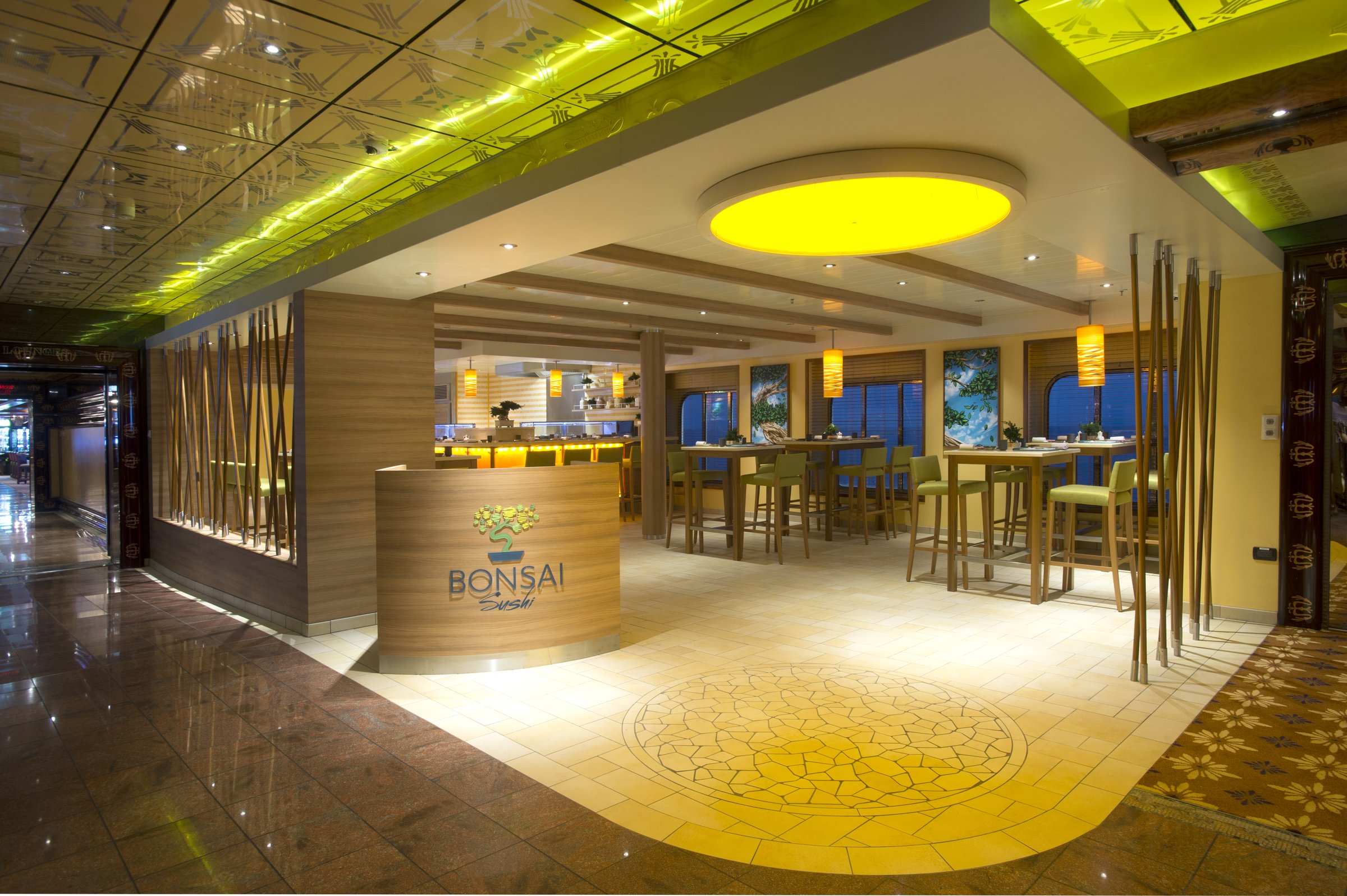 Carnival Legend Bonsai Sushi restaurant with a curved host stand, bamboo screens and bright yellow ceiling accent
