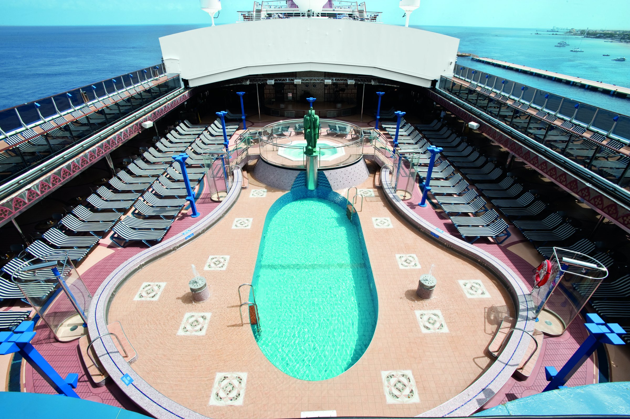 Carnival Legend Avalon pool deck seen from above with the oval pool and loungers on a bright sunny day