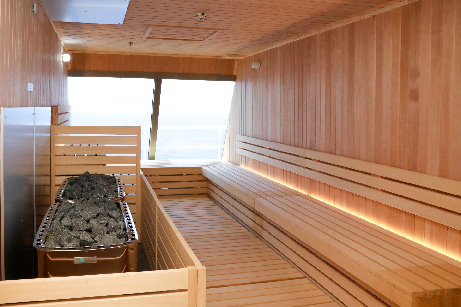 Carnival Liberty Cloud 9 Spa sauna with tiered wooden benches, heater stones and an ocean window