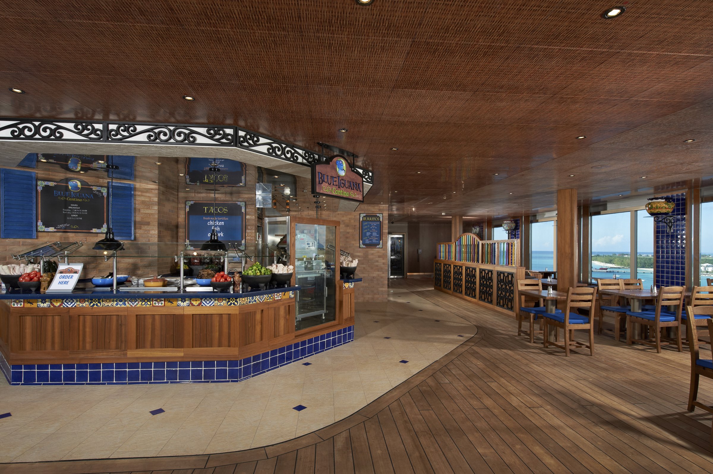 Carnival Liberty Blue Iguana Cantina counter with a blue-tiled front and open seating by the windows