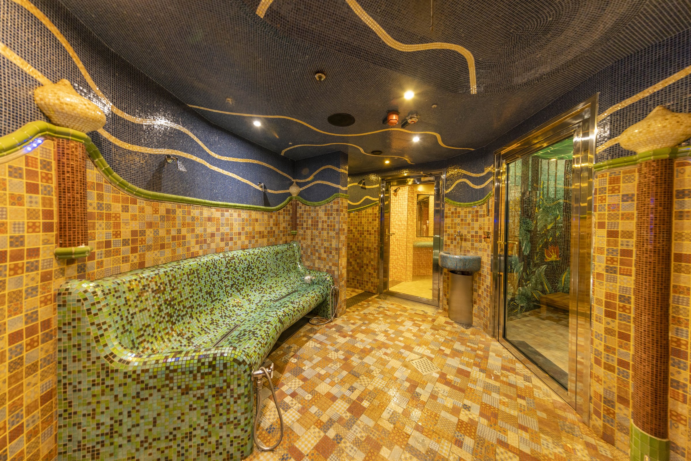 Carnival Luminosa Cloud 9 Spa thermal suite with a mosaic-tiled heated bench and tiled floor
