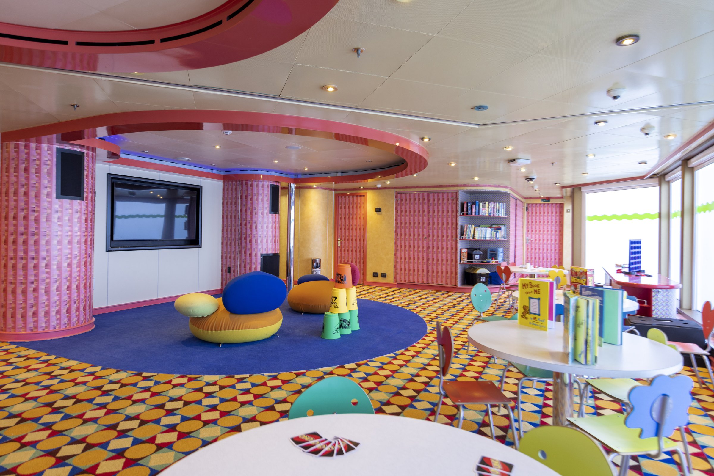 Carnival Luminosa Camp Ocean kids club with colourful carpet, blue circular rug and children's tables
