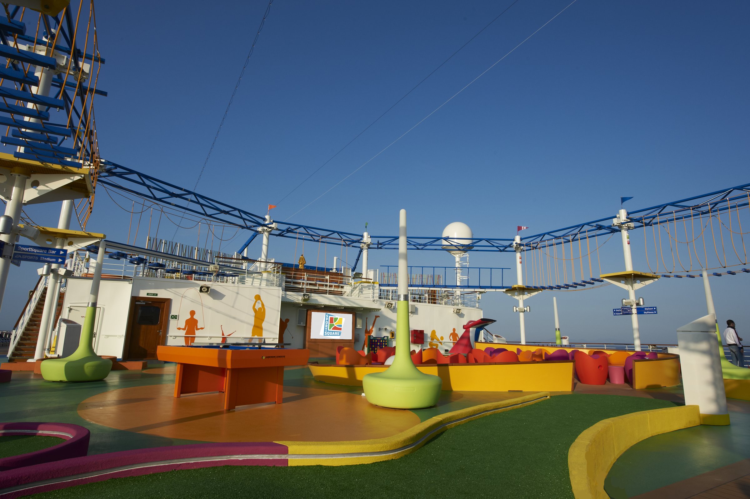 Carnival Magic mini golf and ropes course on the sports deck under a clear blue sky