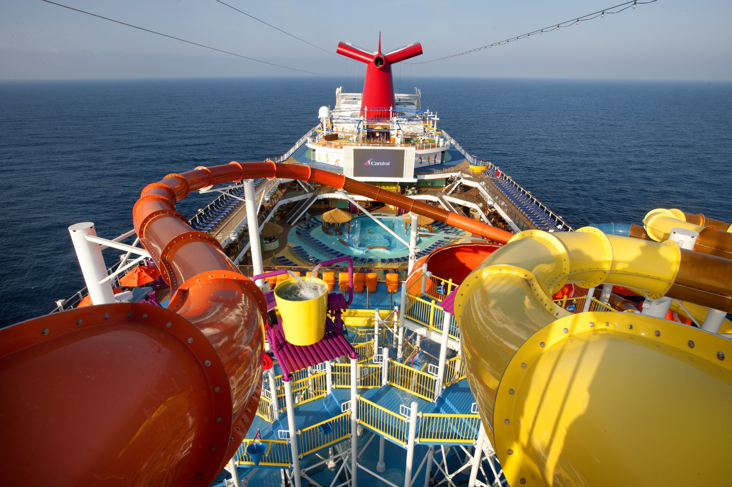 Carnival Magic WaterWorks slides seen from the top deck, with the funnel and pool deck beyond