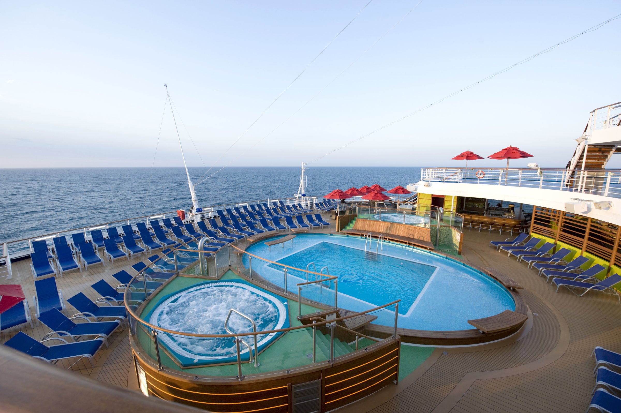 Carnival Magic aft pool and hot tub with blue loungers and open sea views