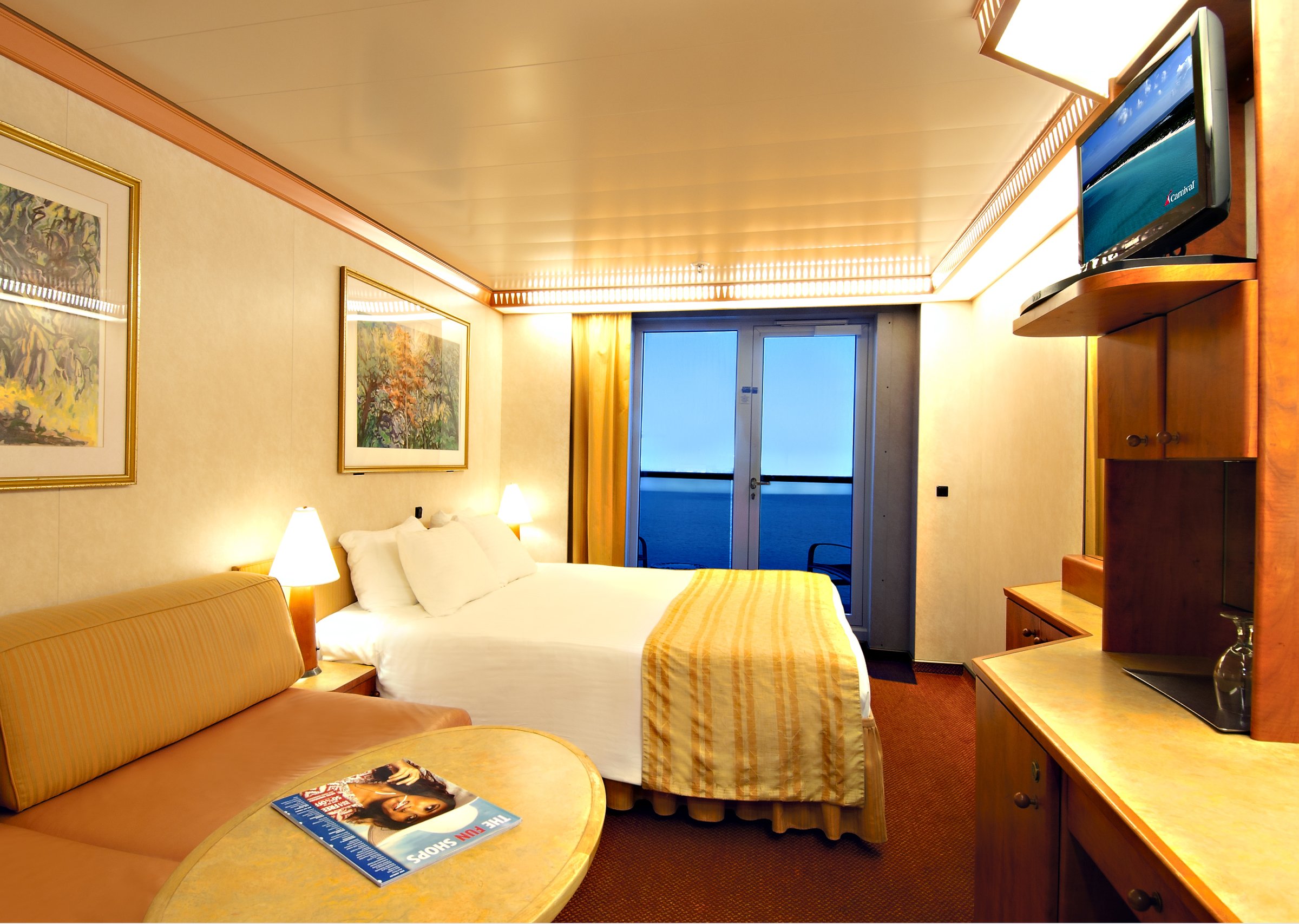 Carnival Miracle balcony stateroom with a sofa bed, striped bedspread and balcony doors to the sea