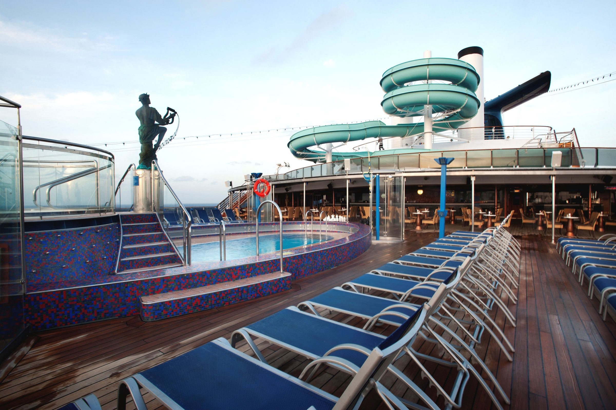 Carnival Miracle Orpheus pool with a mosaic pool edge, loungers and a bright sky