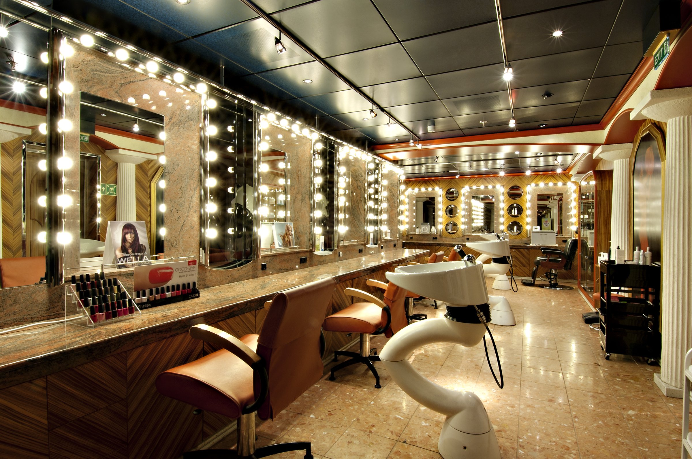 Carnival Miracle beauty salon with mirror lighting, styling chairs and a shampoo basin