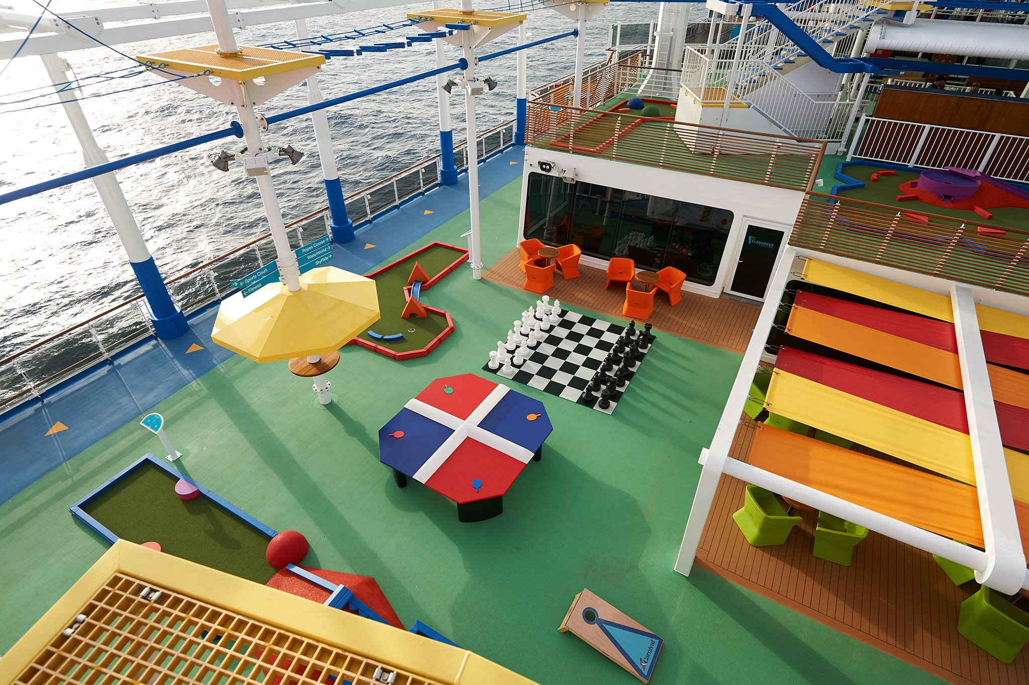 Carnival Panorama sports deck from above with mini golf, giant chess, a ping-pong table and striped sun shades