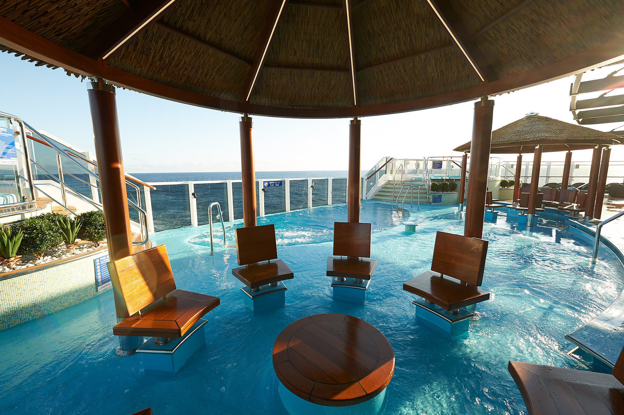 Sunny Havana Pool pavilion seating overlooking the ocean aboard Carnival Panorama