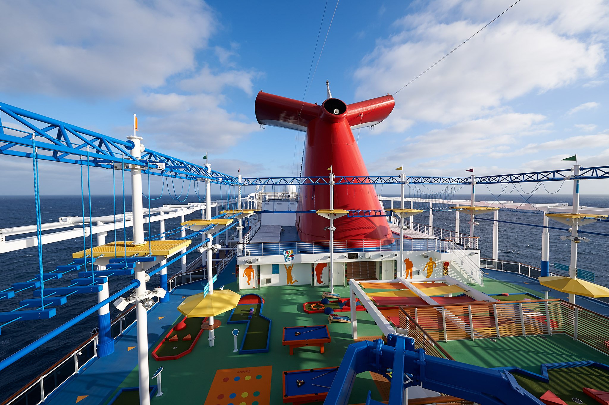 Carnival Panorama ropes course and sports deck beneath the red winged funnel on a sunny day