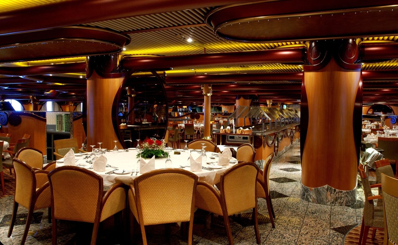 Carnival Paradise Destiny dining room, round tables with white linens and warm lighting