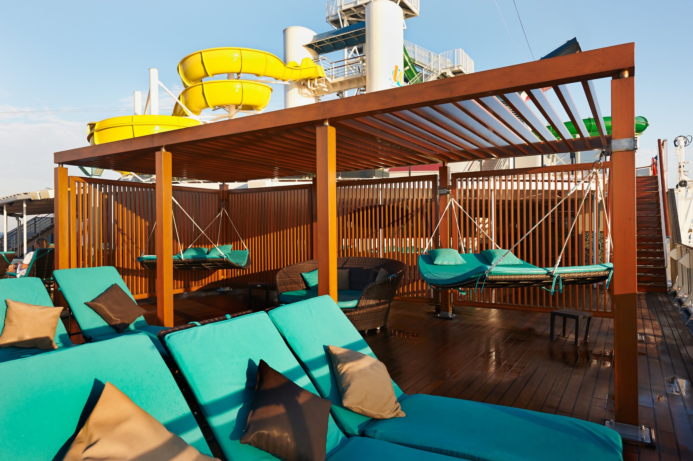 Carnival Pride Serenity adult retreat with teal loungers, cabanas and hanging daybeds