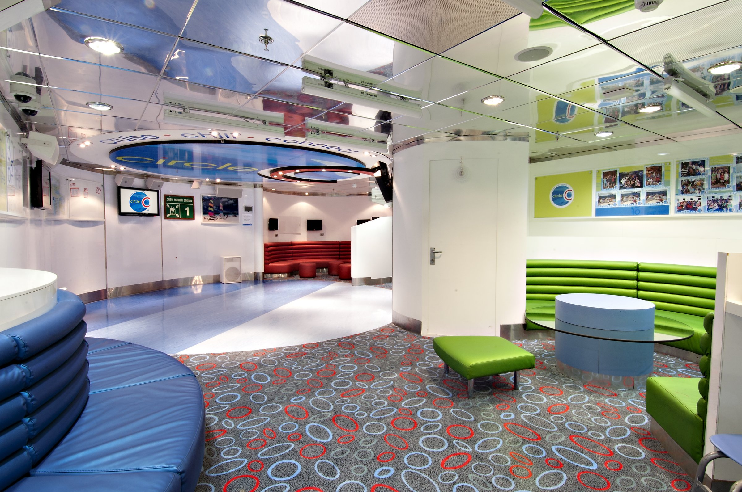 Carnival Pride Circle C teen and kids club lounge with green banquettes and a patterned carpet