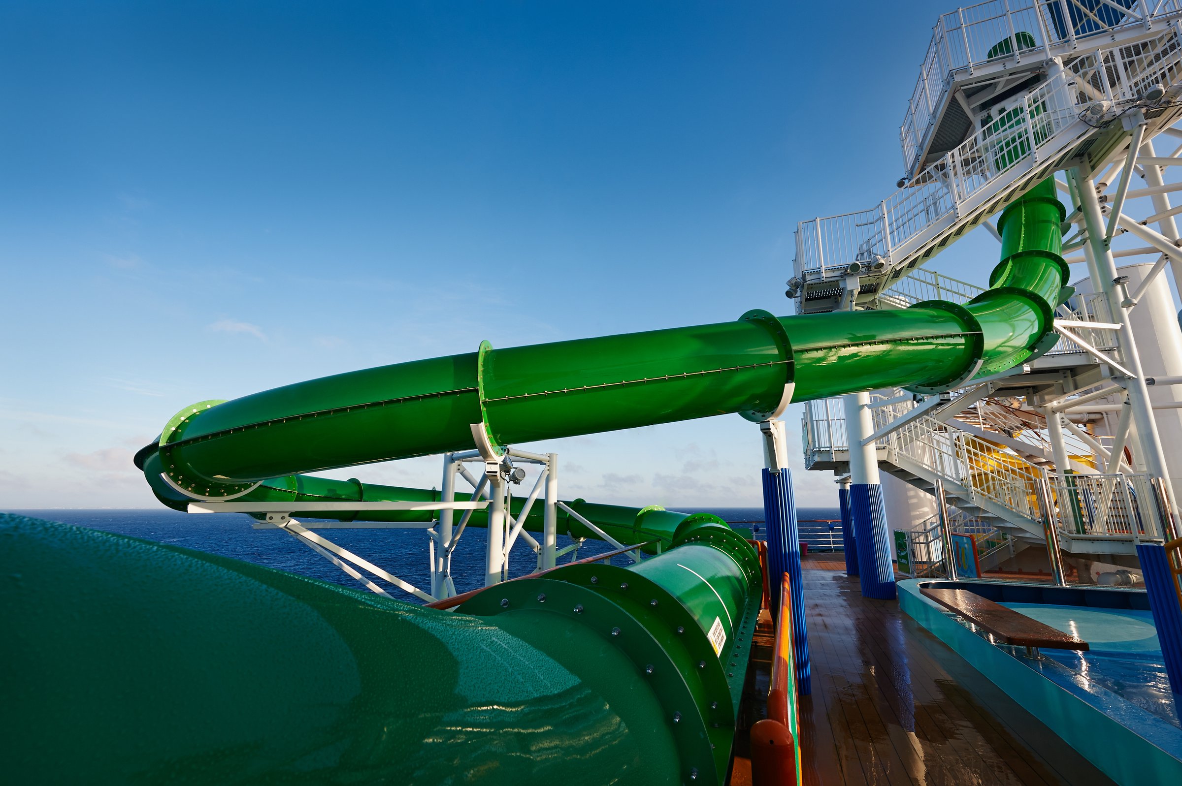 Carnival Pride WaterWorks green waterslide curving above the deck on a bright day