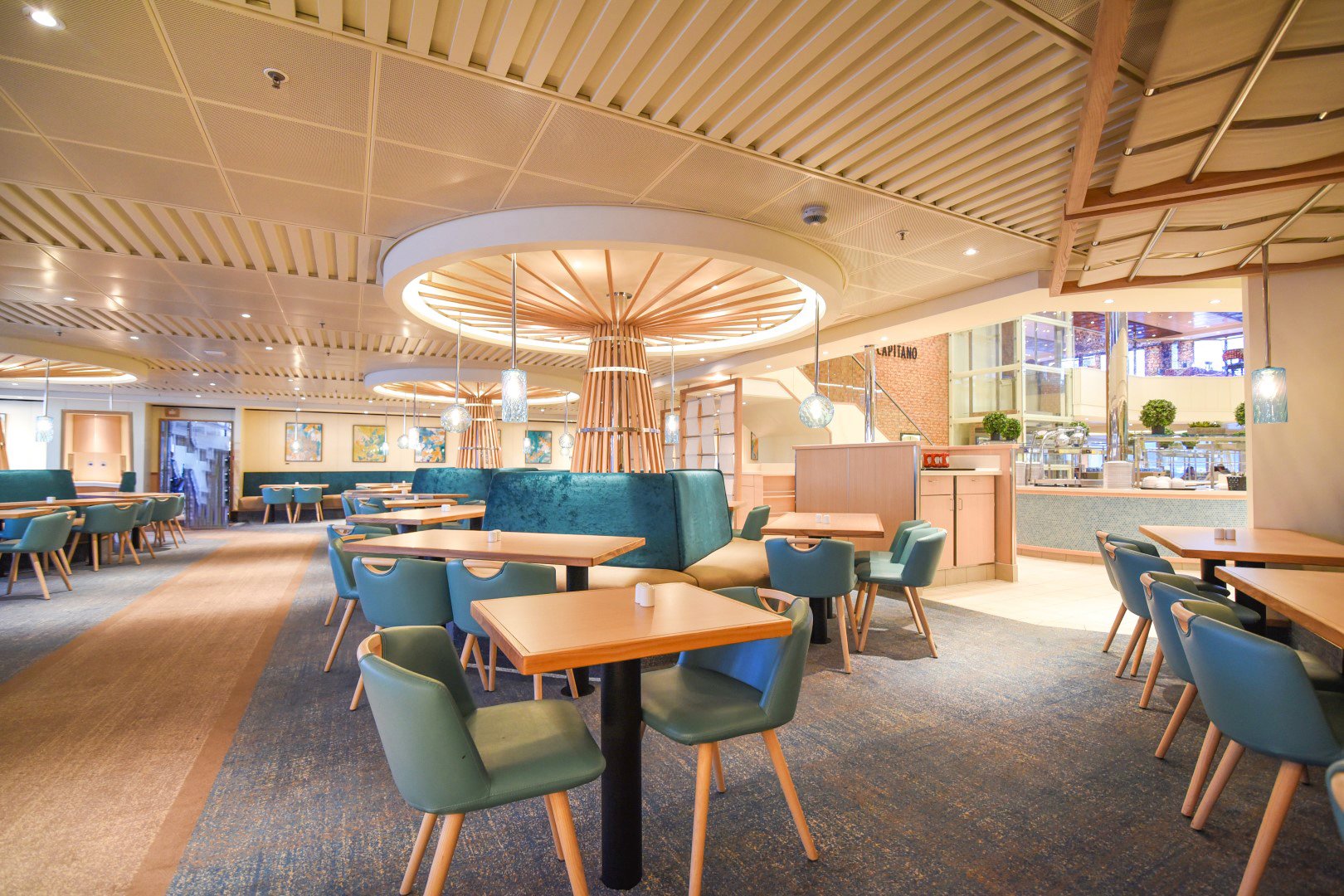 Carnival Radiance Lido Marketplace with teal chairs, wooden tables and a circular slatted ceiling feature
