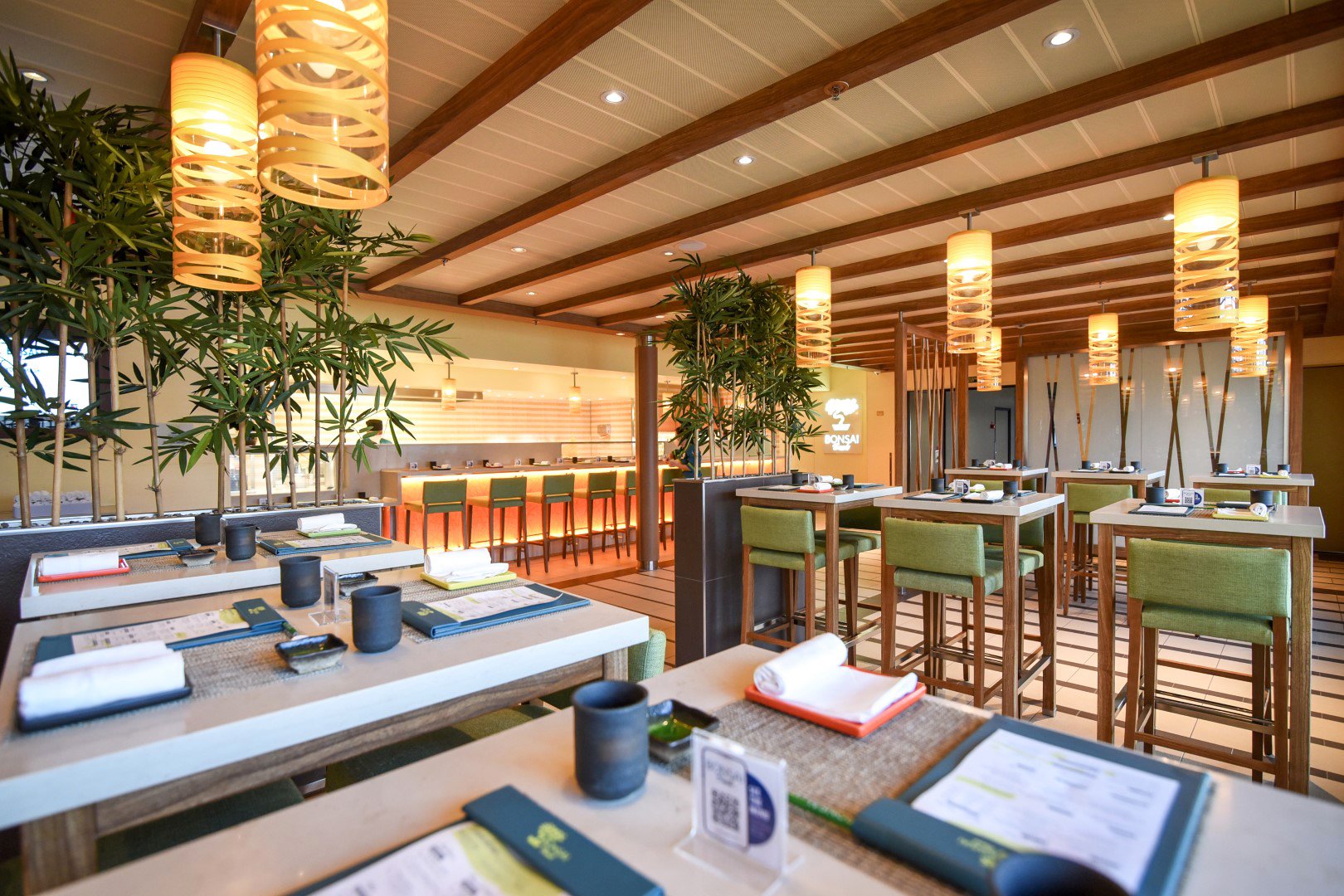 Carnival Radiance Bonsai Sushi with green bar stools, paper lanterns and bamboo plants
