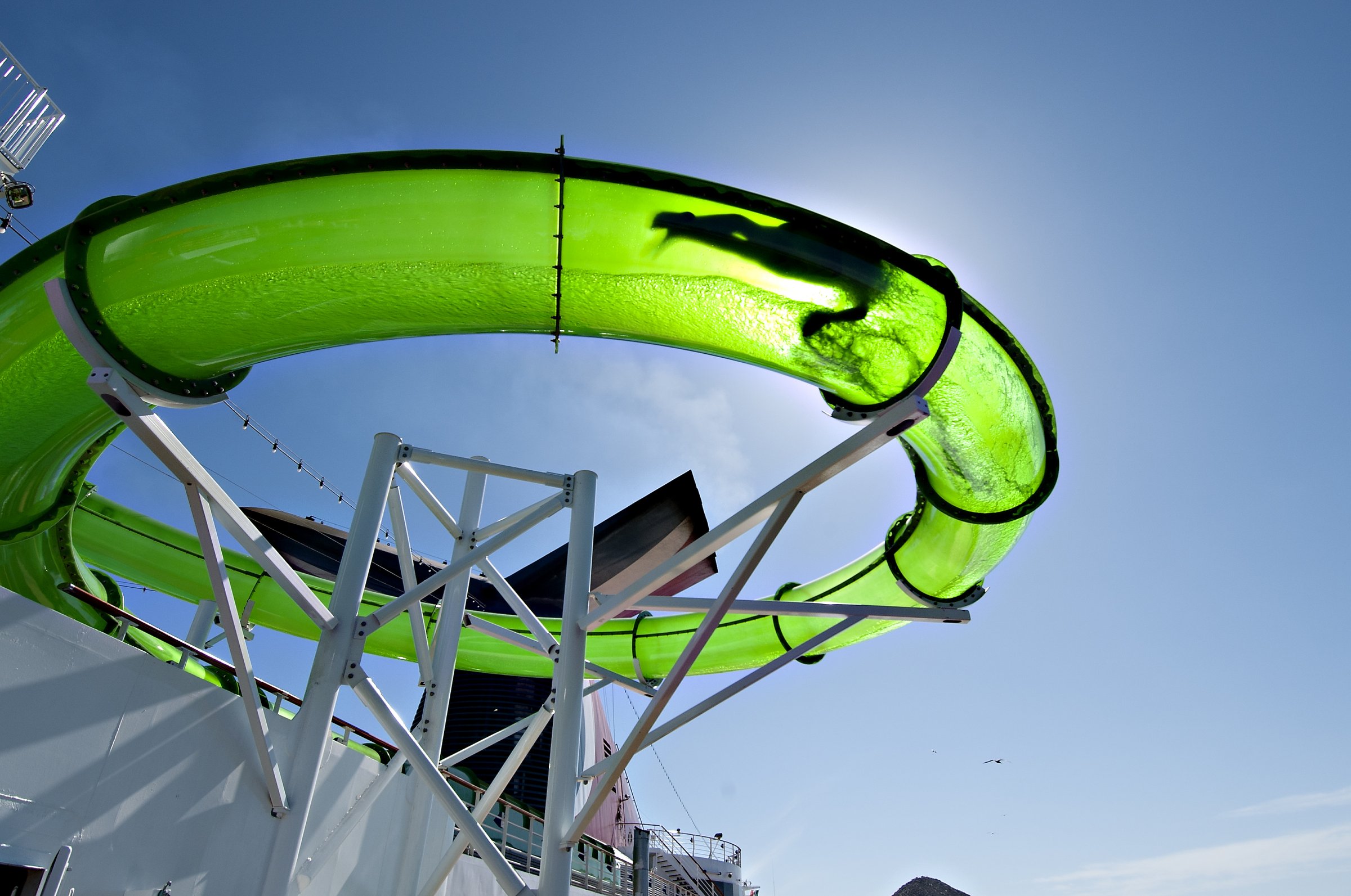 Carnival Spirit WaterWorks green slide looping against a bright blue sky