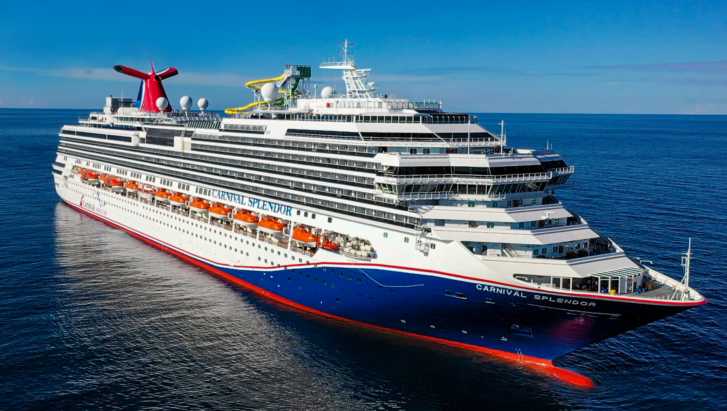 Carnival Splendor blue-hull aerial exterior on open ocean, midday