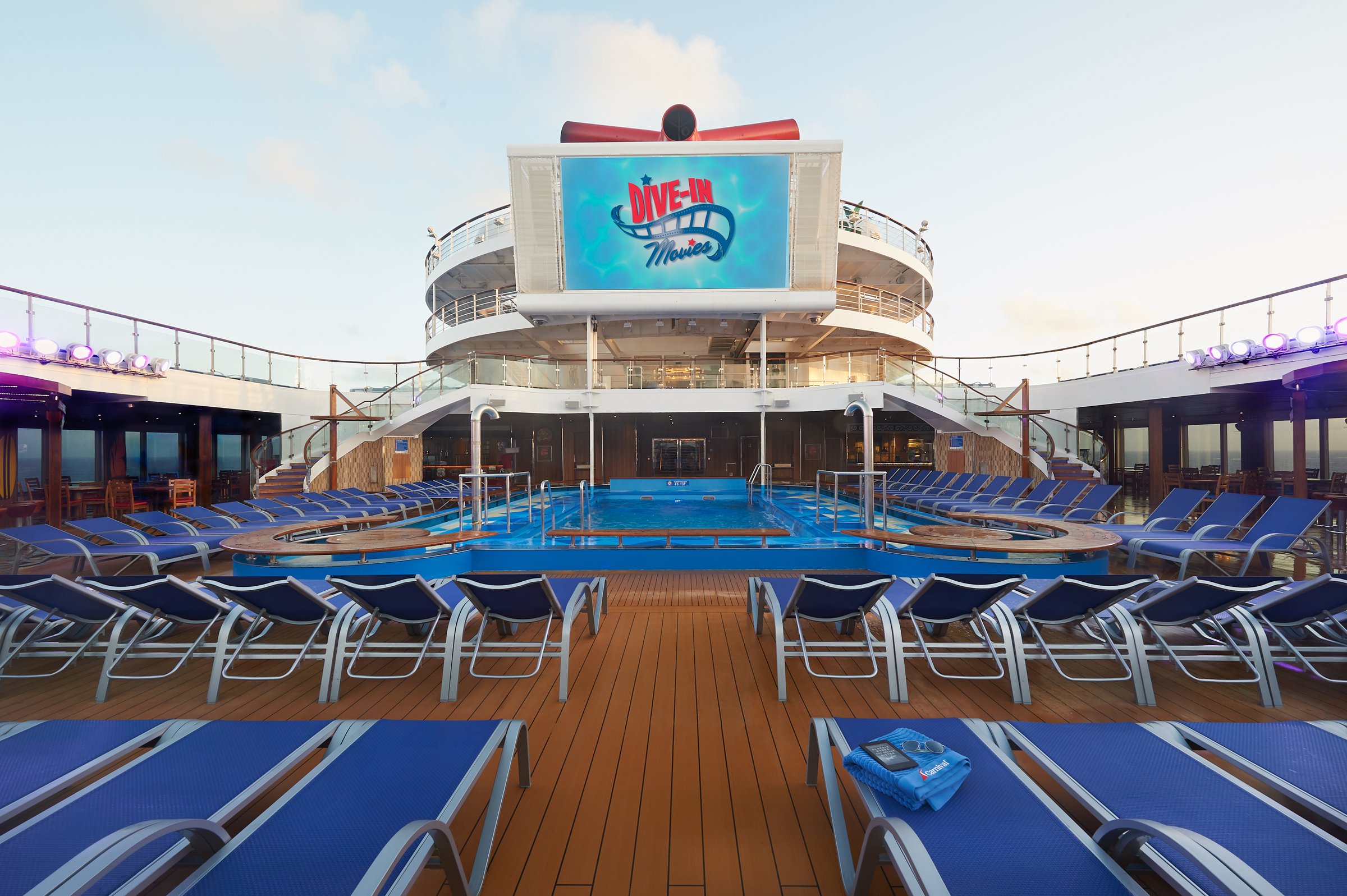 Carnival Sunrise main pool deck with blue loungers, the pool and the large Dive-In movie screen