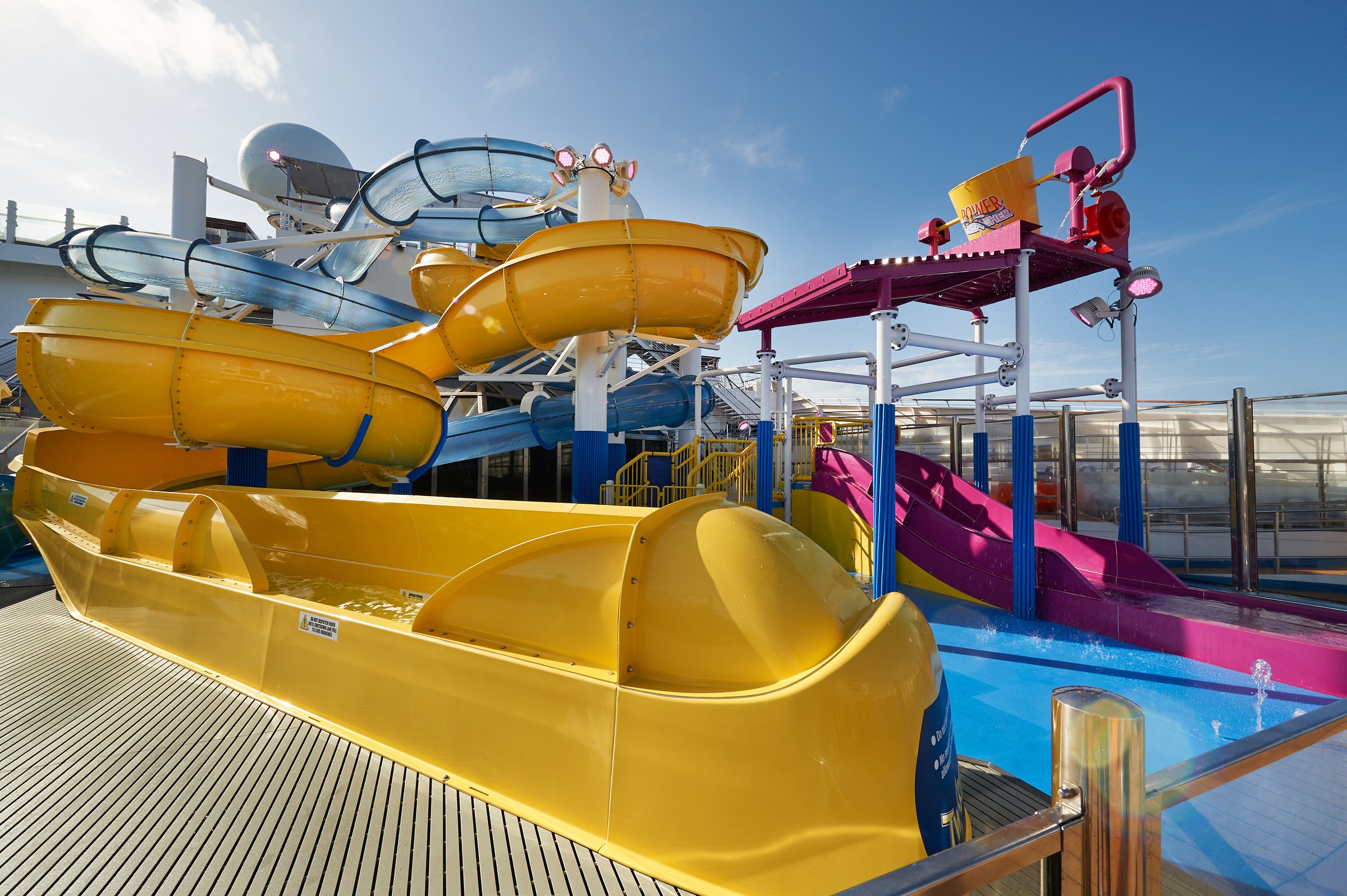 Carnival Sunrise WaterWorks yellow and blue slides and splash area in bright sun