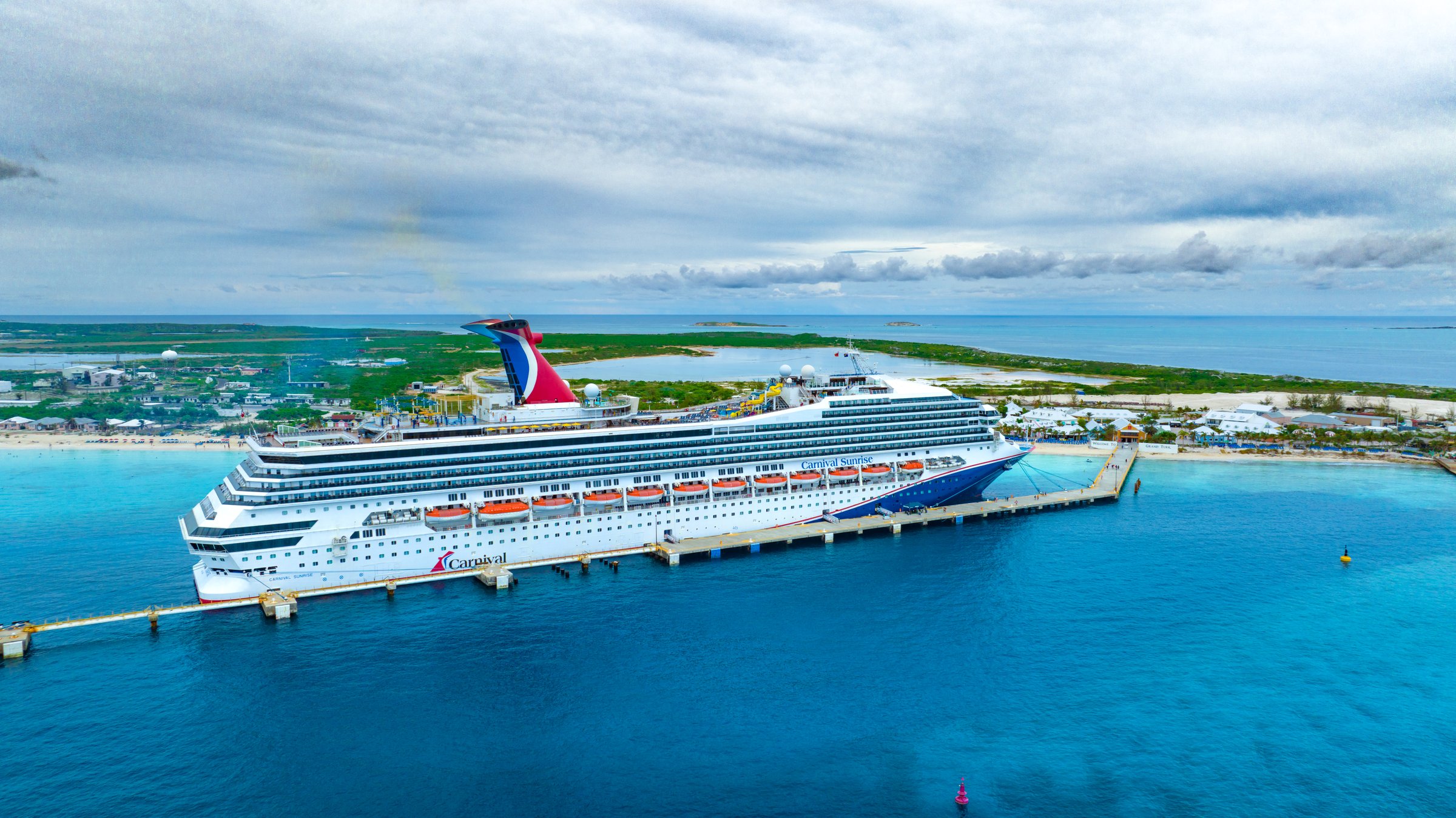 Carnival Sunrise docked at Grand Turk with turquoise water and the island behind