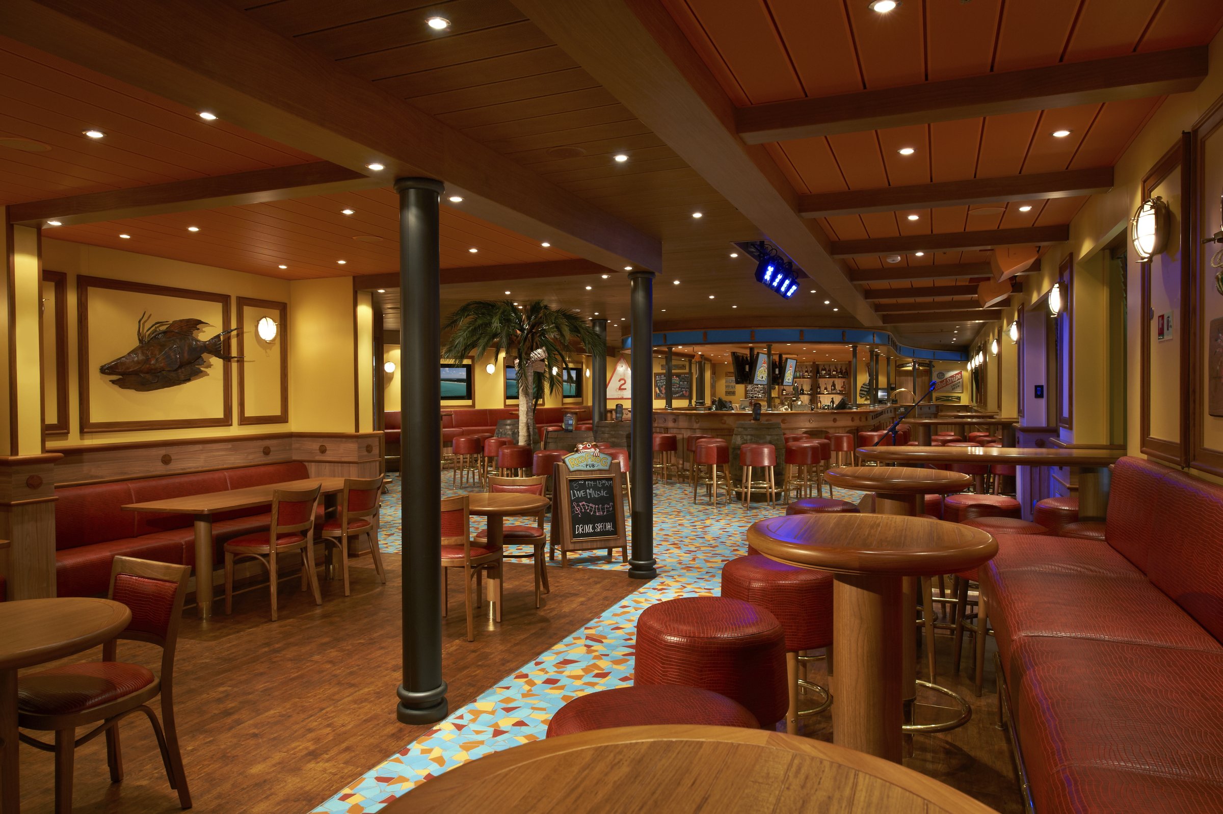 Carnival Sunshine RedFrog Pub with wooden tables, red banquettes and a colourful tiled floor