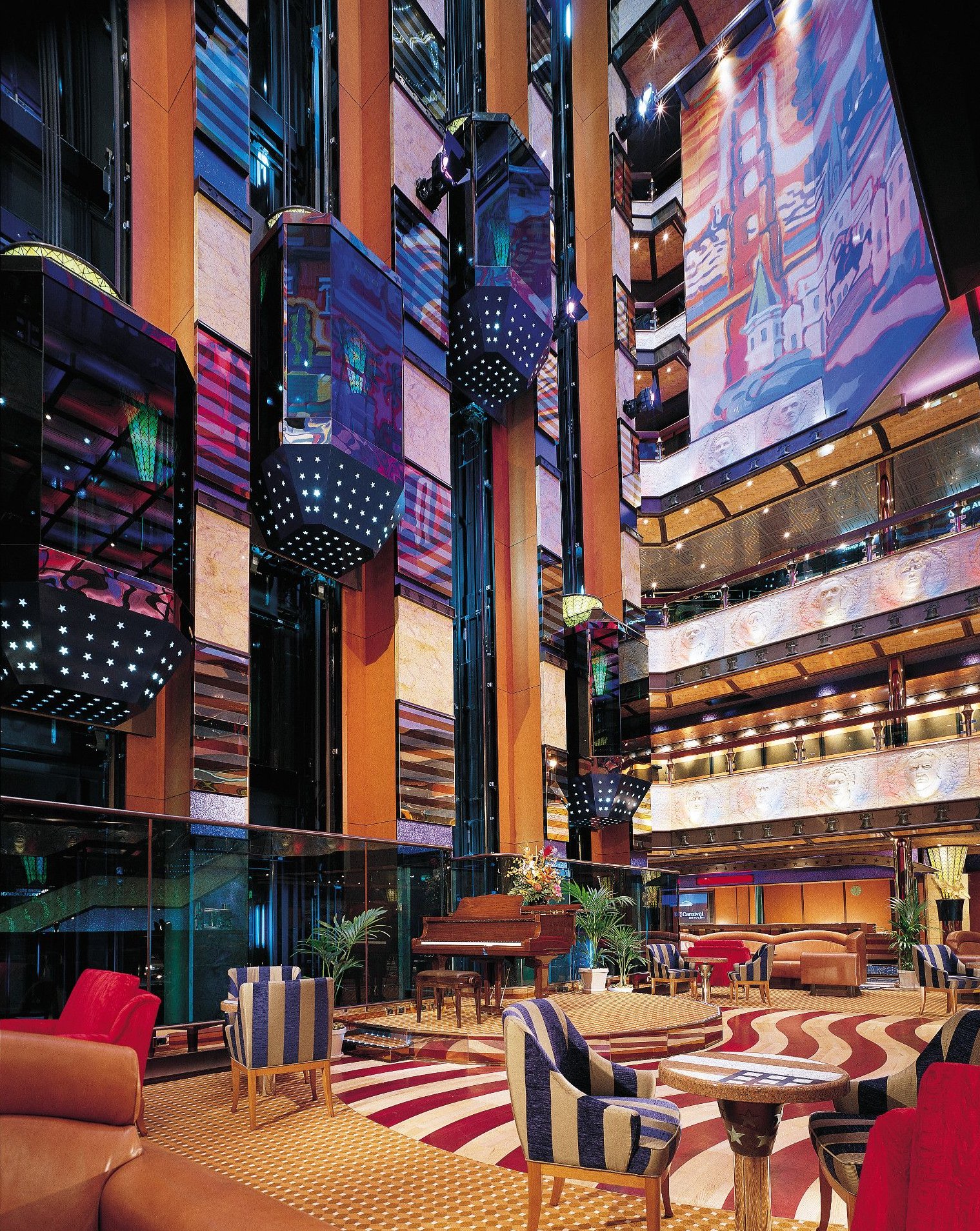 Carnival Valor multi-deck atrium with glass elevators and a piano lounge area